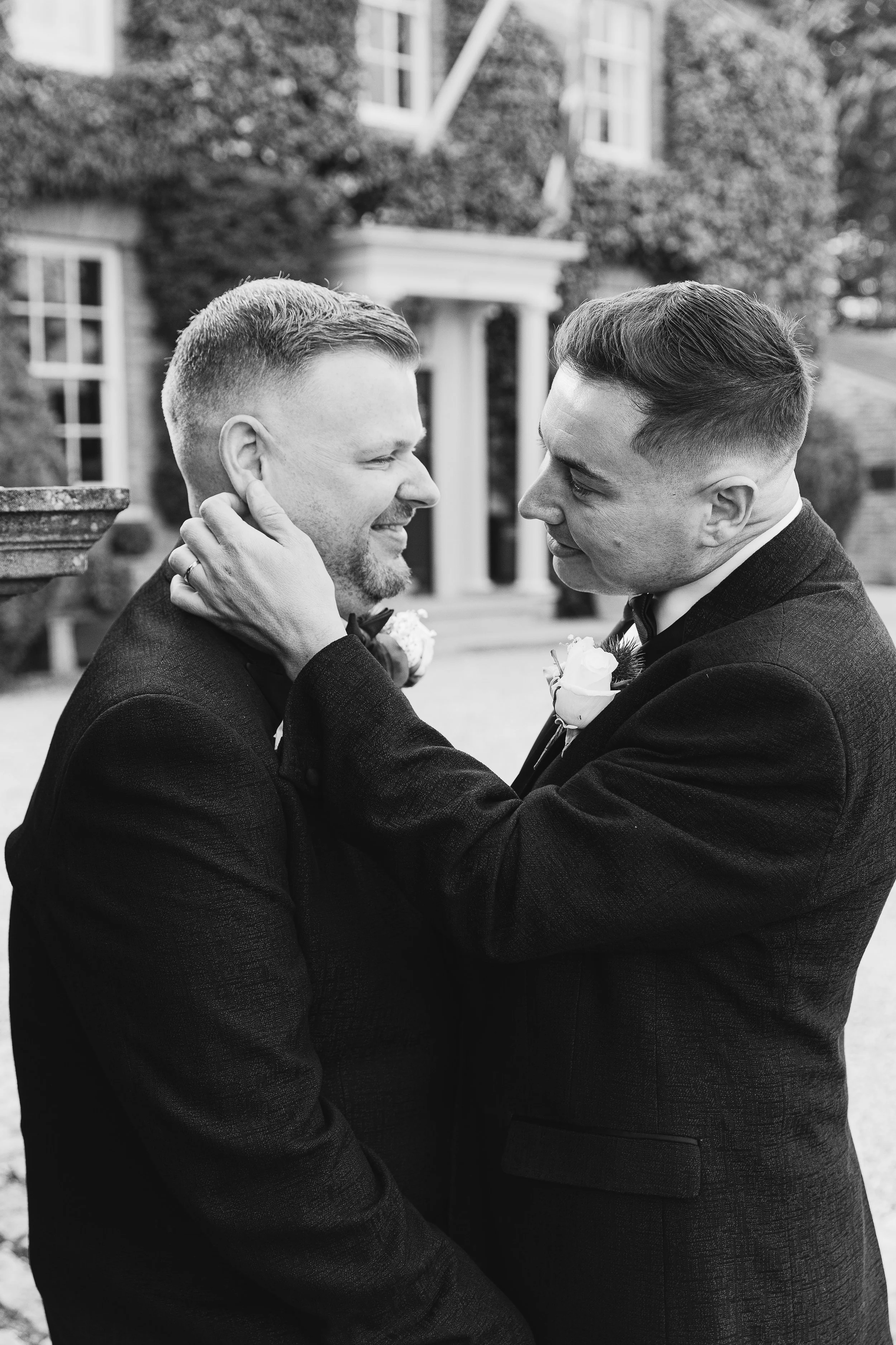 Two grooms facing each other at their wedding at Friern Manor in essex. A black and white image if this same sex LGBTQ+ wedding 