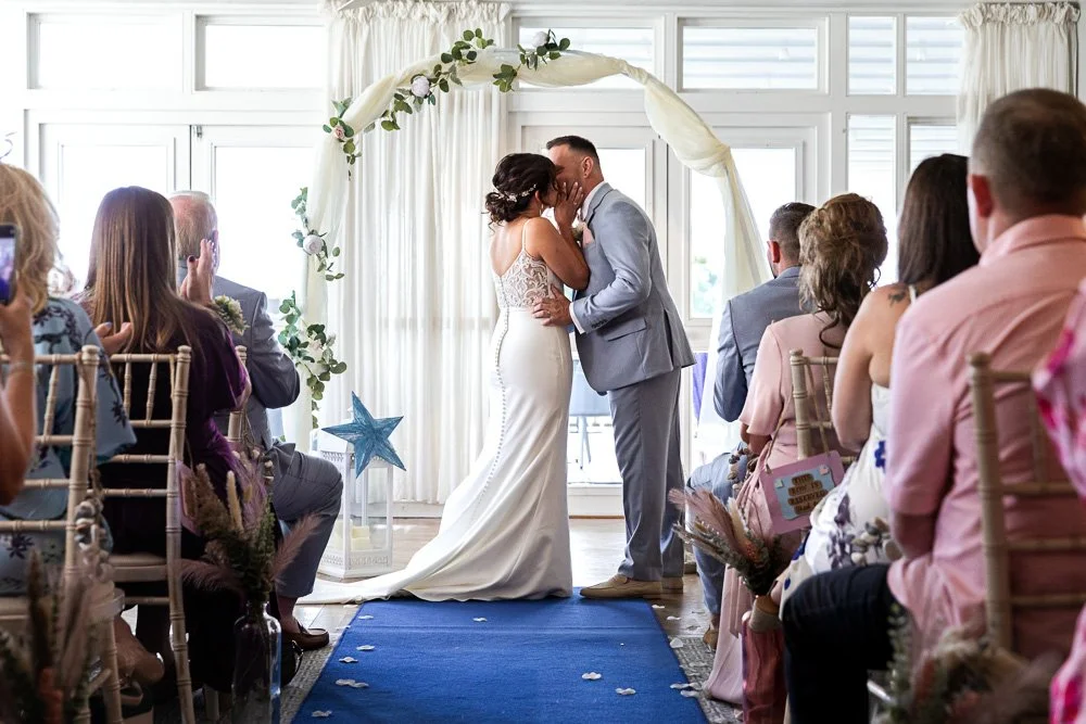 A bride and grooms first kiss at their christchurch harbour hotel wedding 