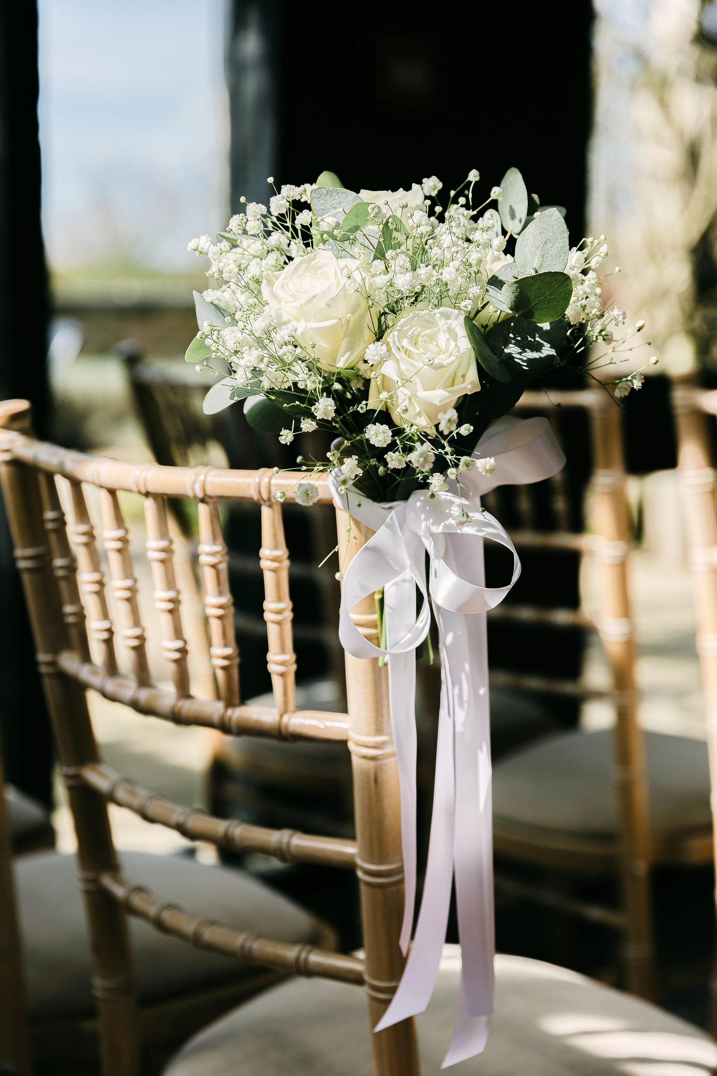 Wedding flower arrangement tied to a chair at South Farm In Royston