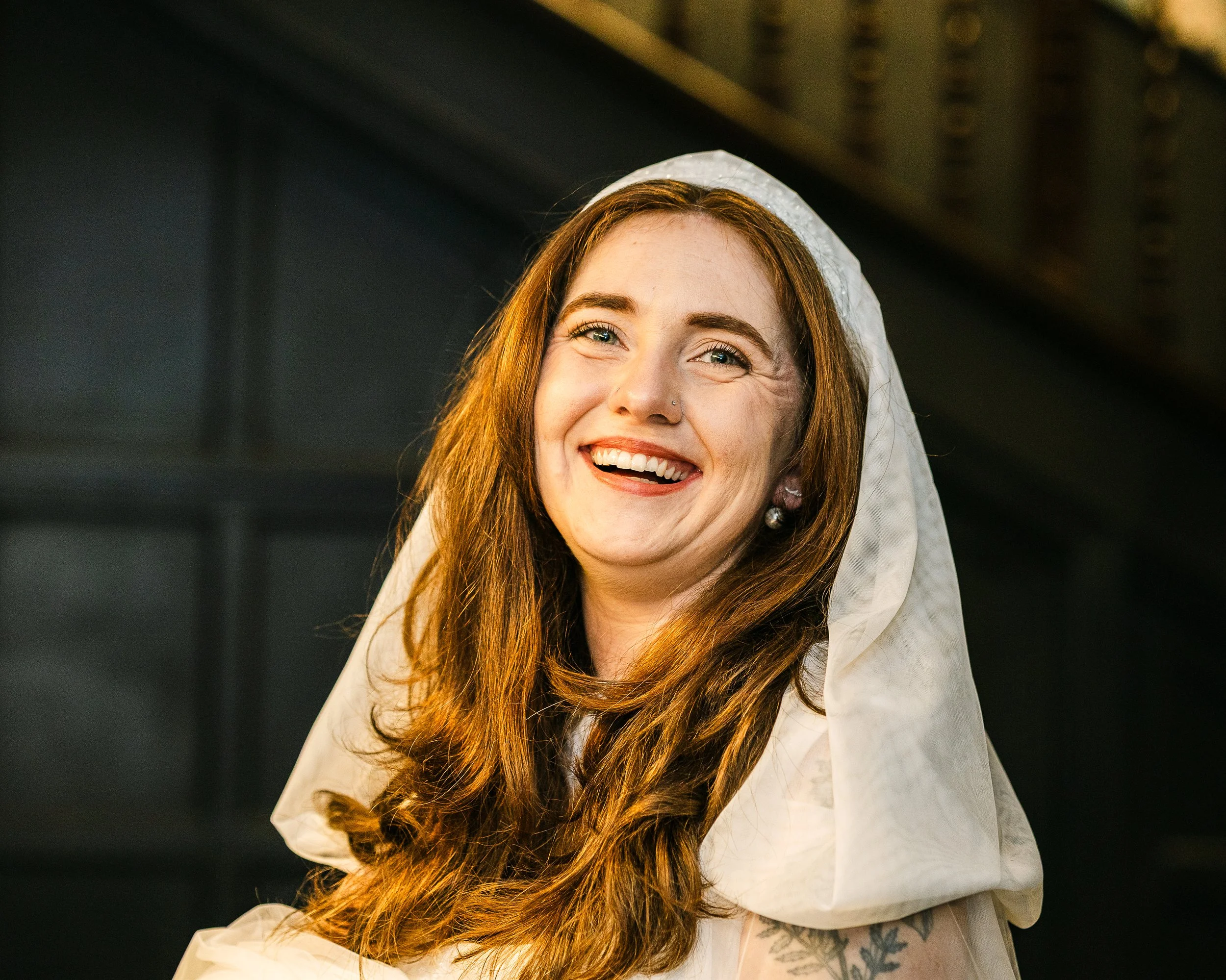 Bride smiling at the camera wearing a hooded veil at her wedding in hertfordshire