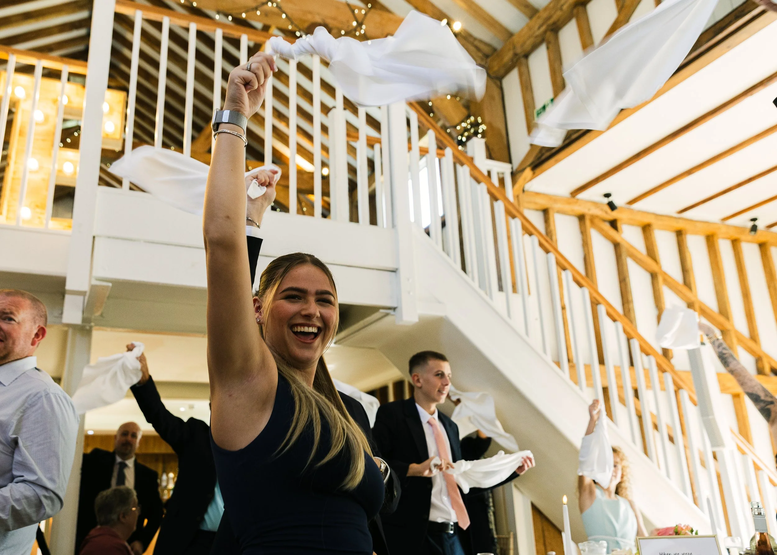 Woman waving her napkin above her head at Milling Barn, a Hertfordshire Wedding venue
