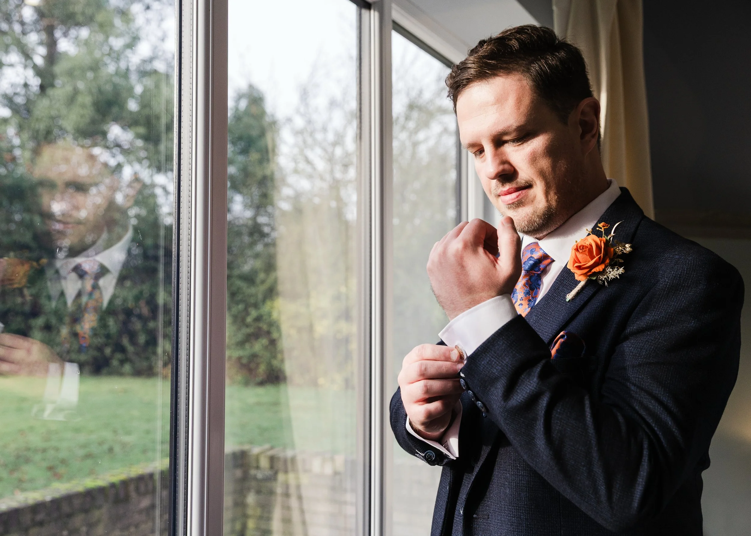 Groom adjusting his cufflinks at his Hertfordshire wedding