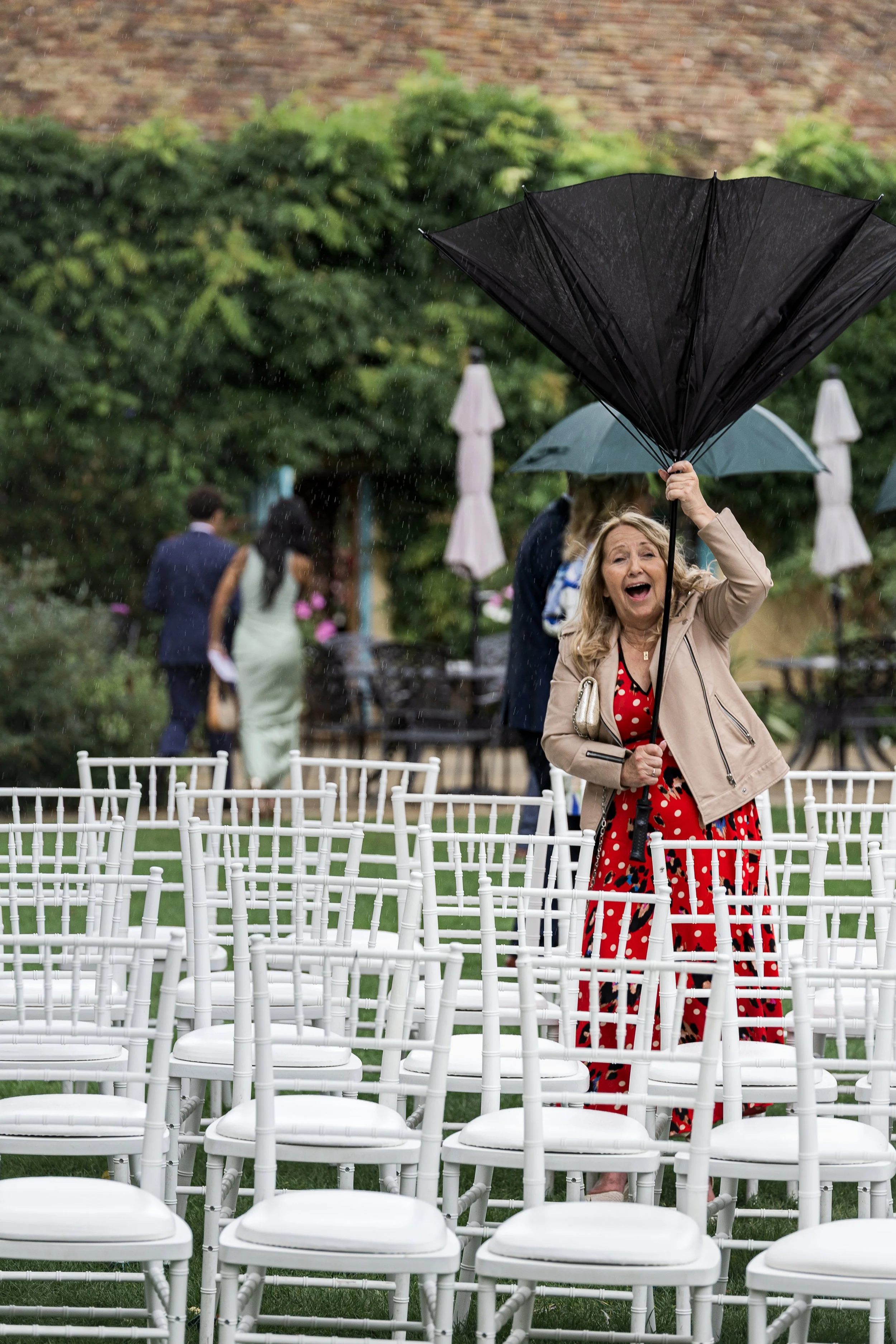 A guest at South Farm Hertfordshire. Taken during a storm, her umbrella has turned inside out and she has a look of surprise on her face