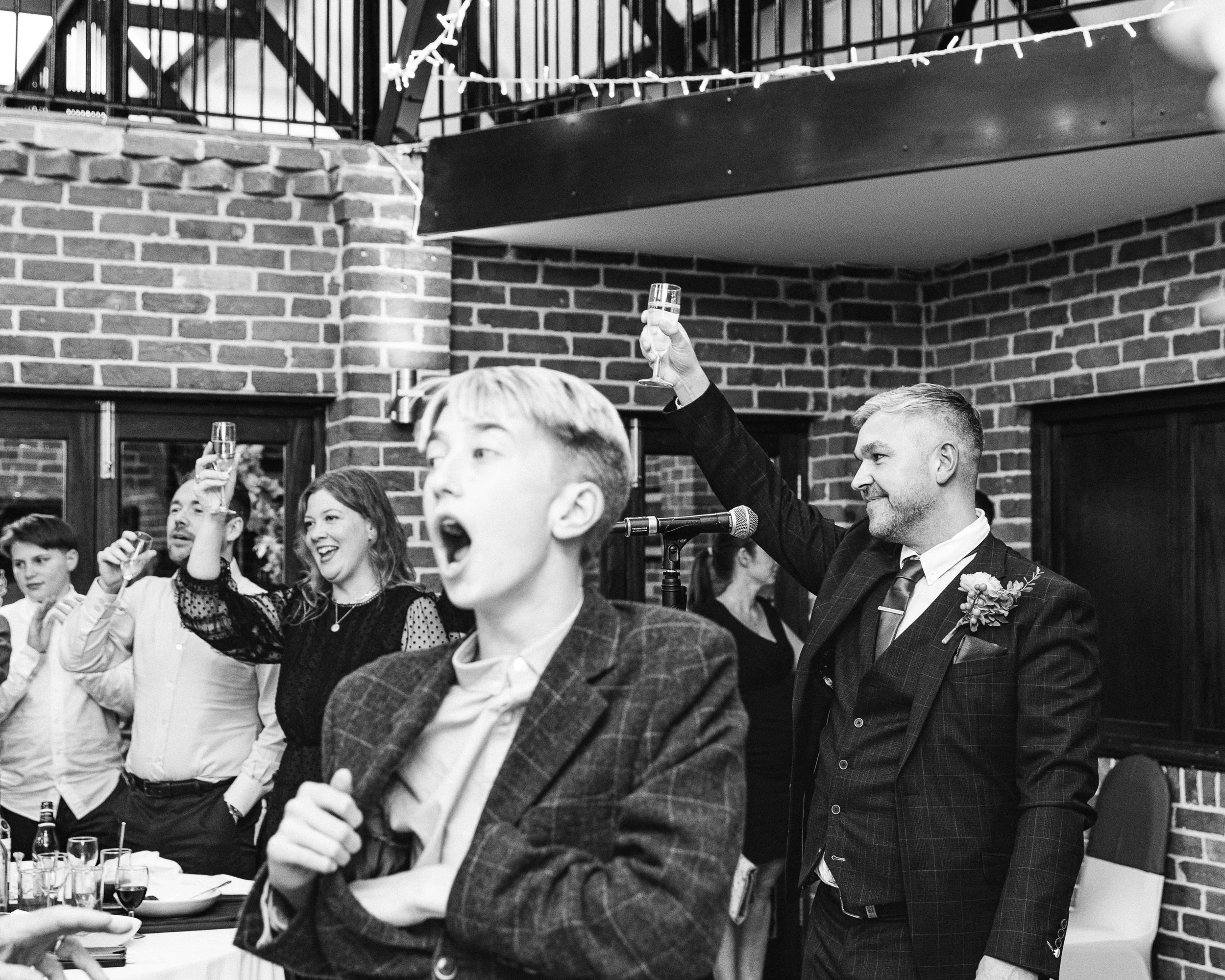 Bets man raising a glass at a wedding during the best man speech