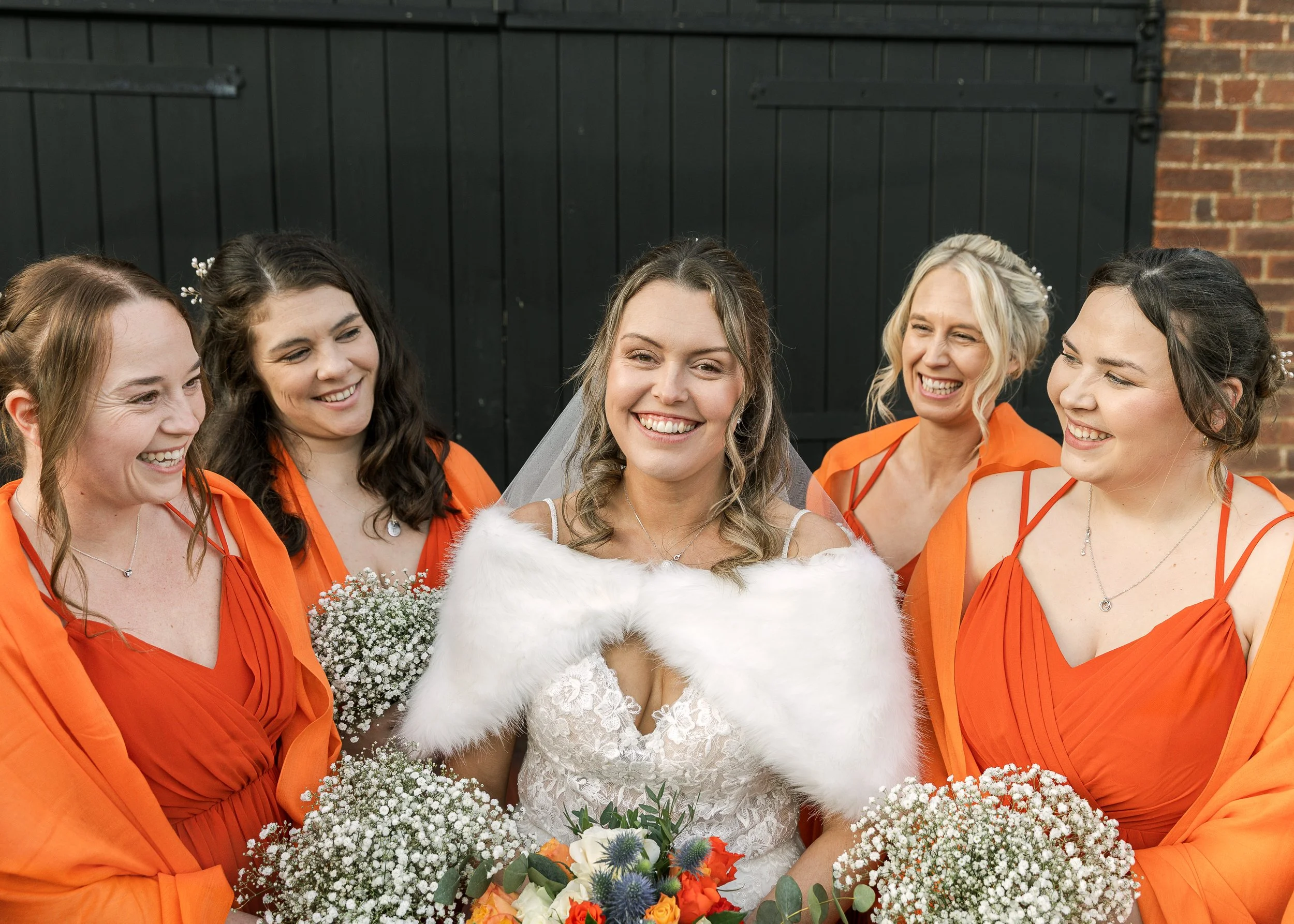 Winter bride and her bridesmaids standing together at a wedding venue in hertfordshire