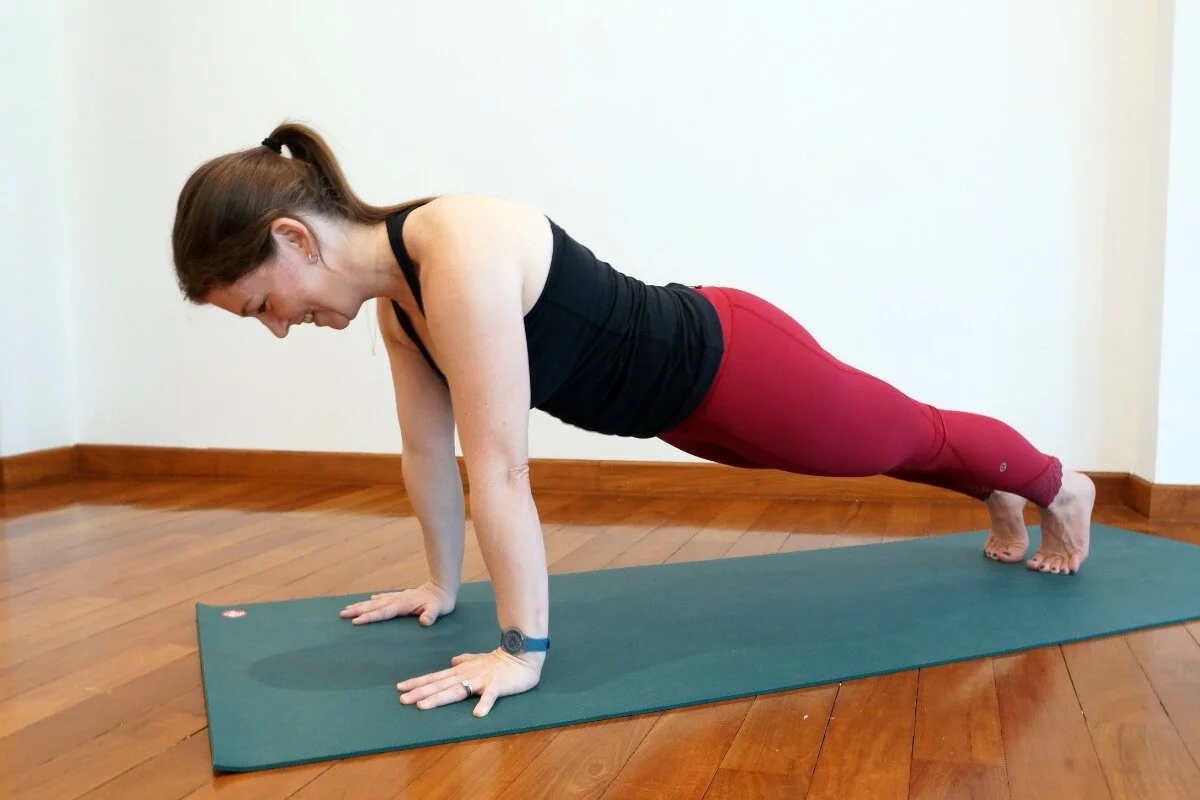 Dr. Trish Corley in plank posture demonstrating full body alignment to prevent wrist pain in yoga