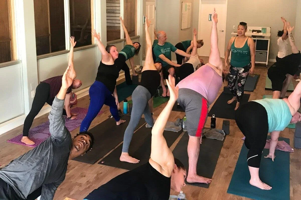 Yoga teacher guiding a group class through conscious breathing to shift the nervous system