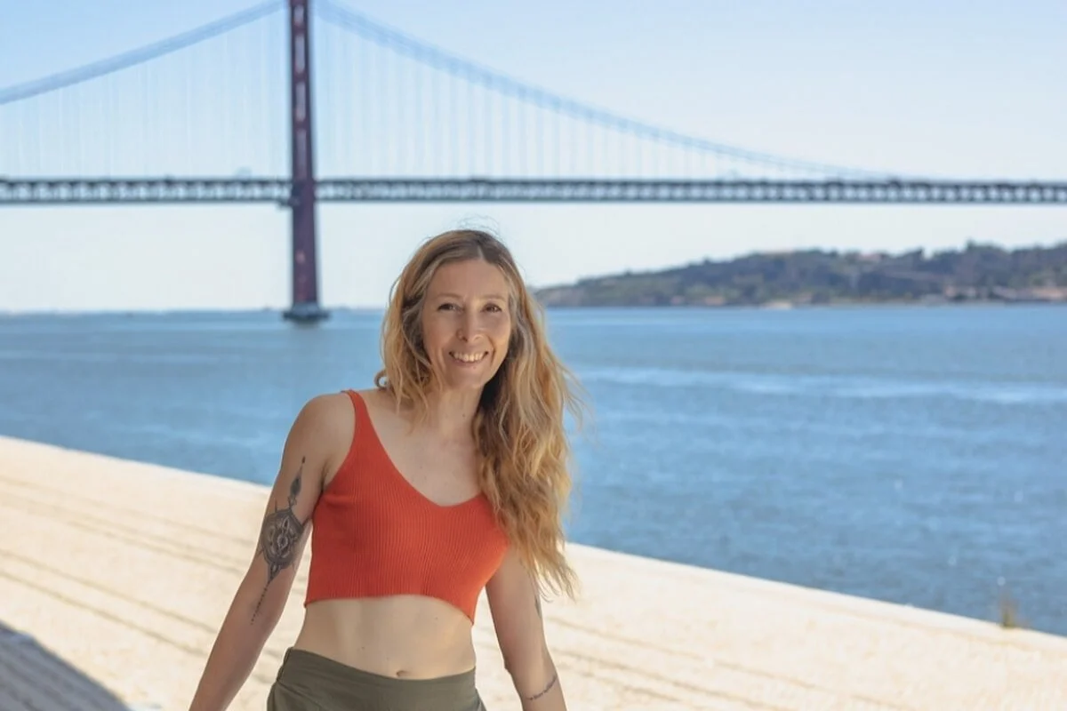 Melody Billings, vinyasa yoga teacher and graduate of the Elevate Your Impact Mentorship with Dr. Trish Corley in Lisbon with bridge and river in background