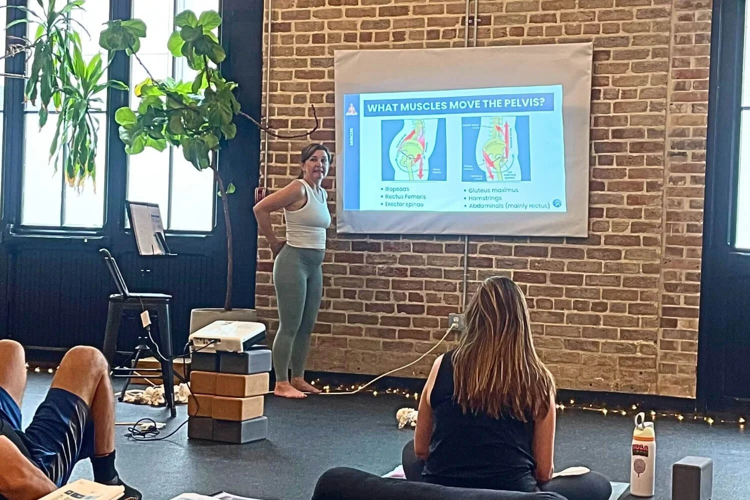 Yoga teacher learning anatomy in a training setting