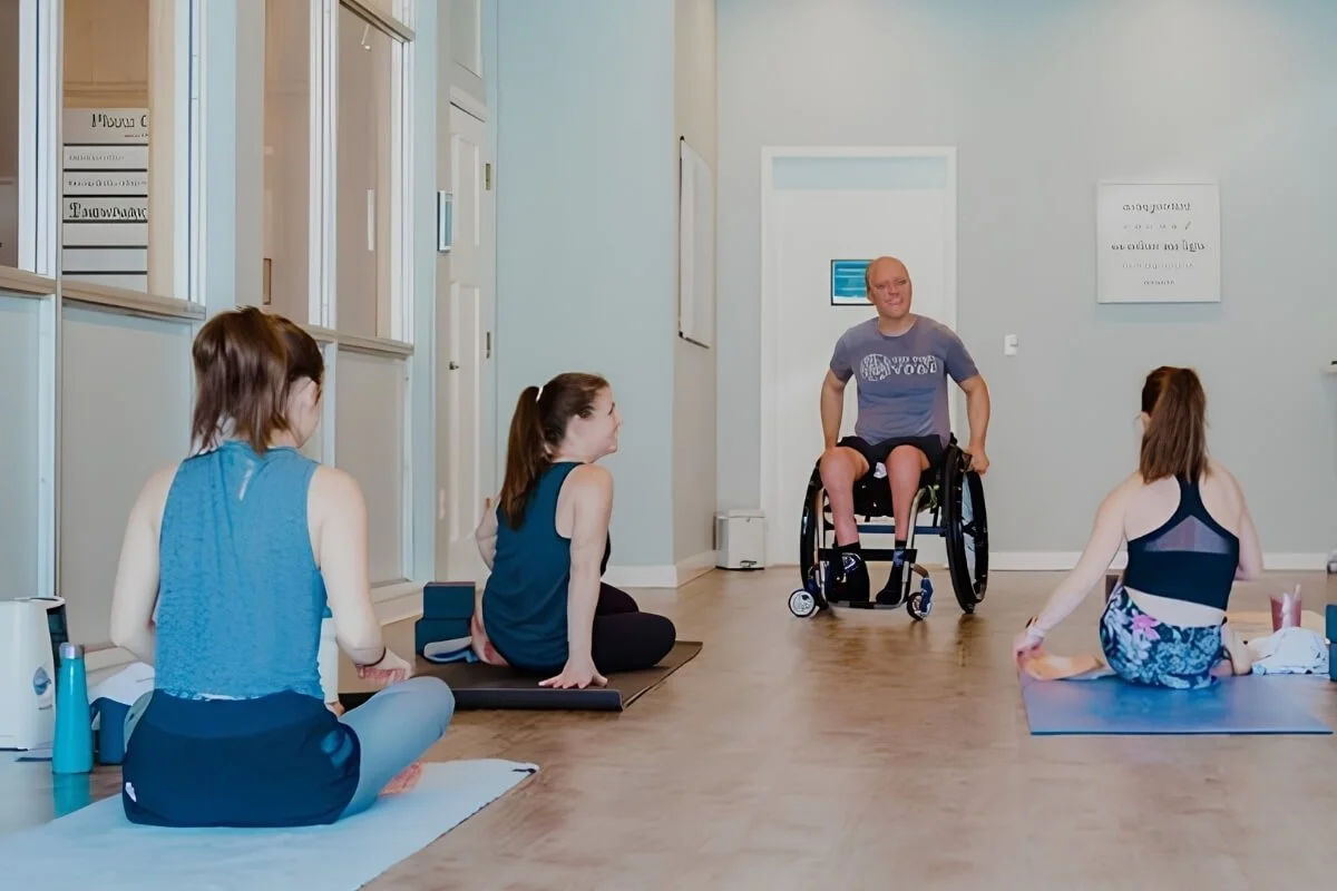 A yoga teacher who uses a wheelchair leading a class, one example of how every teacher finds their own way to teach