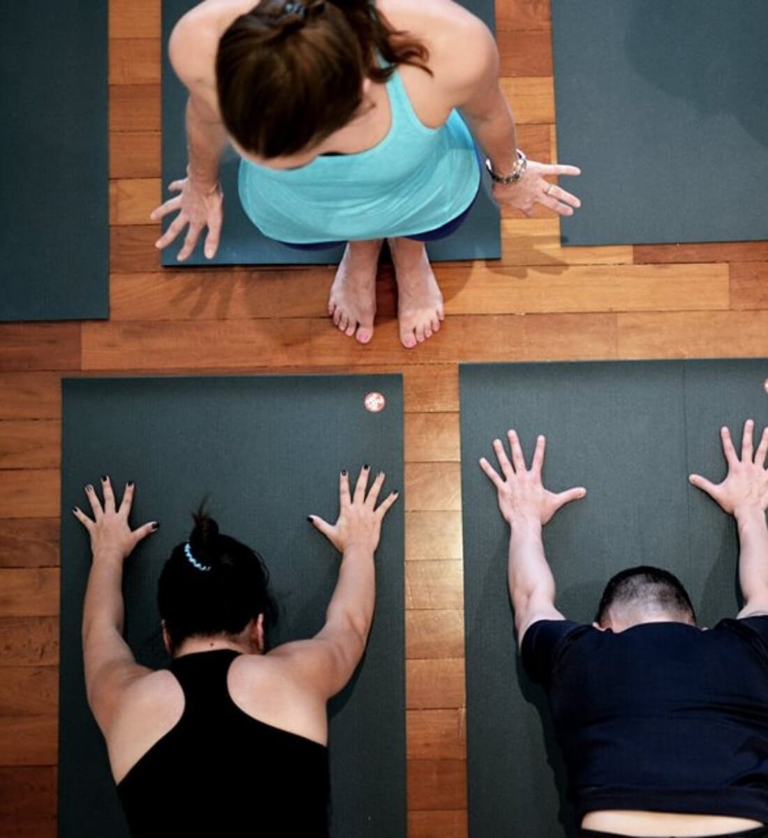 Yoga students practicing cueing on mats seen from above