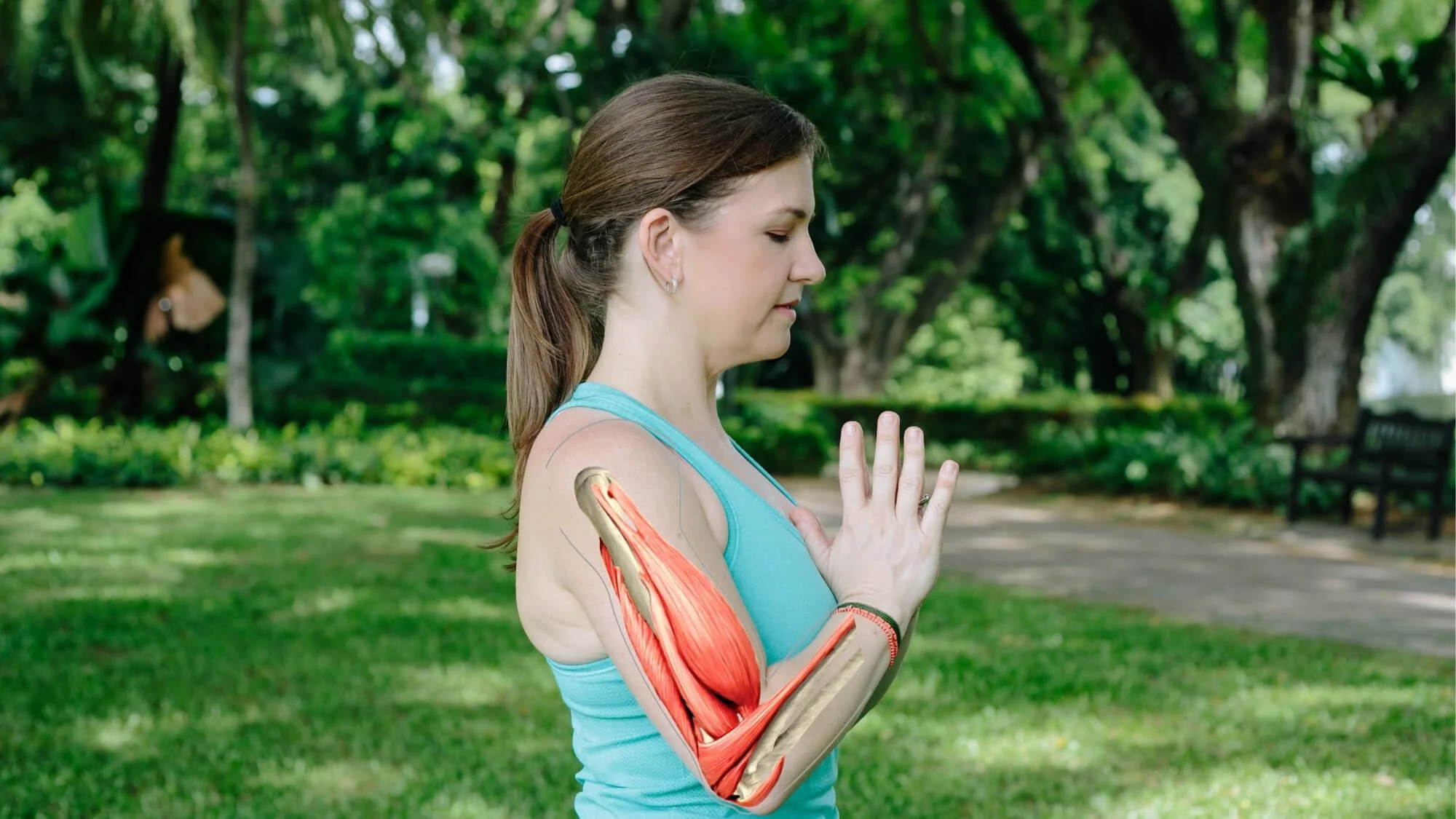 Dr. Trish Corley in prayer position showing arm muscle anatomy for yoga