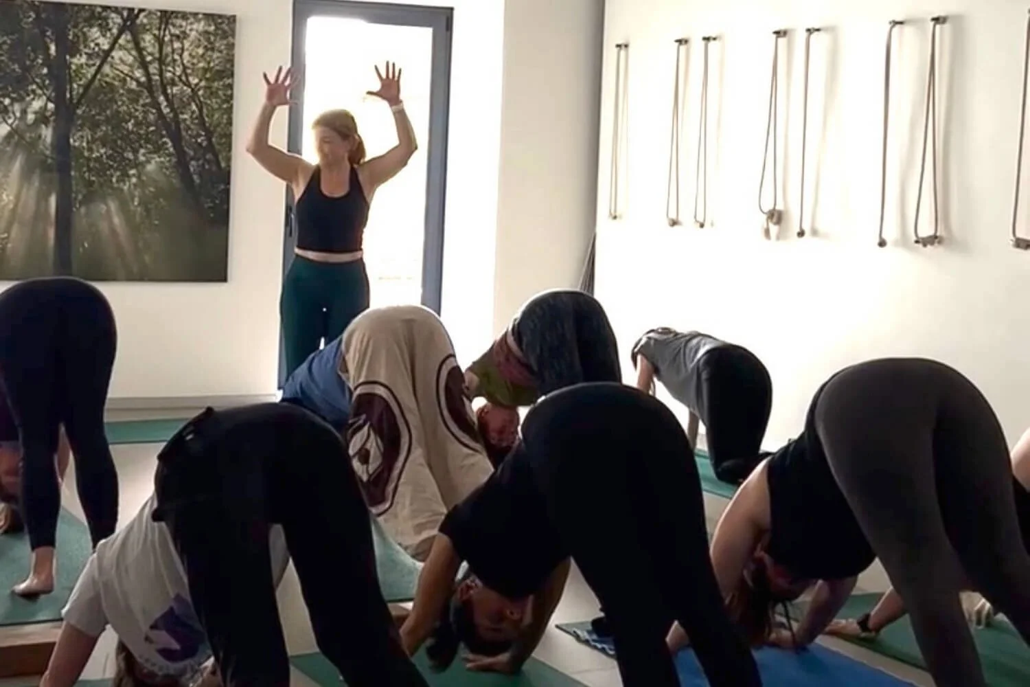 Yoga teacher positioned to observe and connect with students during class