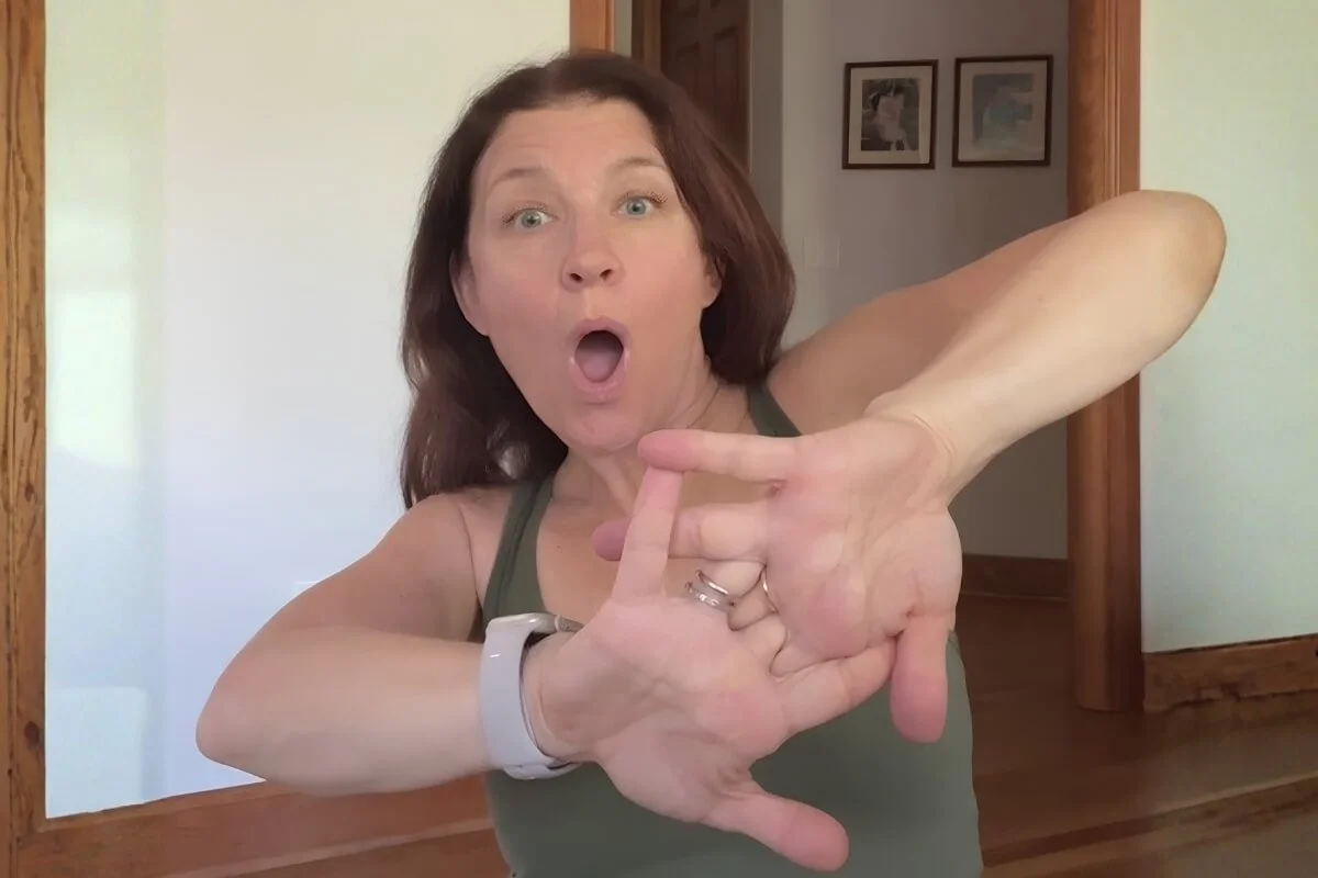 Yoga teacher mobilizing her wrist to demonstrate why joints crack in yoga