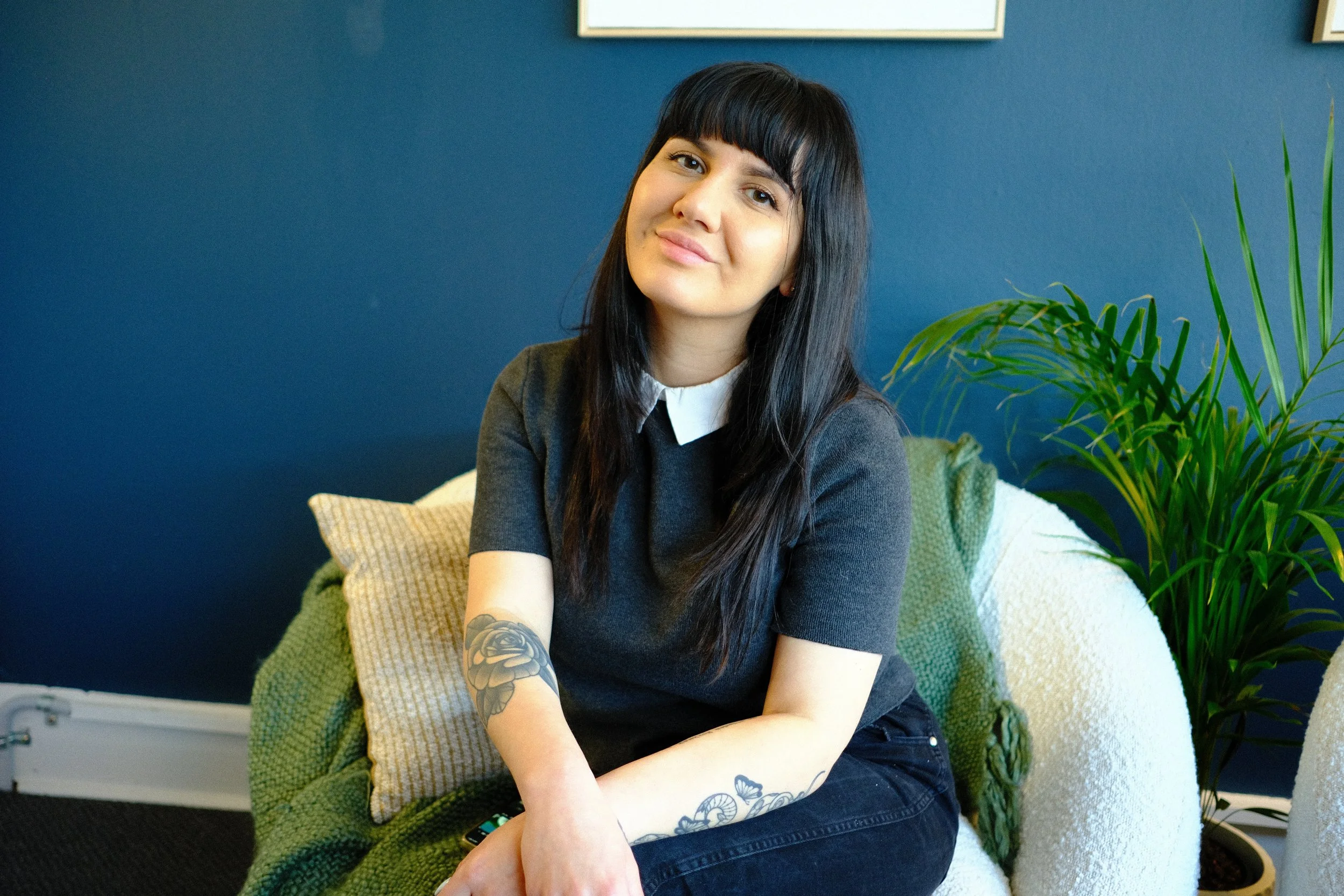 AMHSW accredited mental health social worker with tattooes sitting and smiling