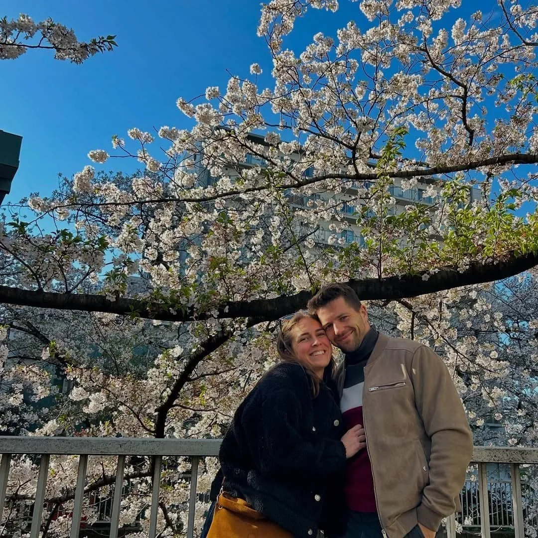 Couple sous un arbre en fleurs, photo romantique en voyage au Japon.