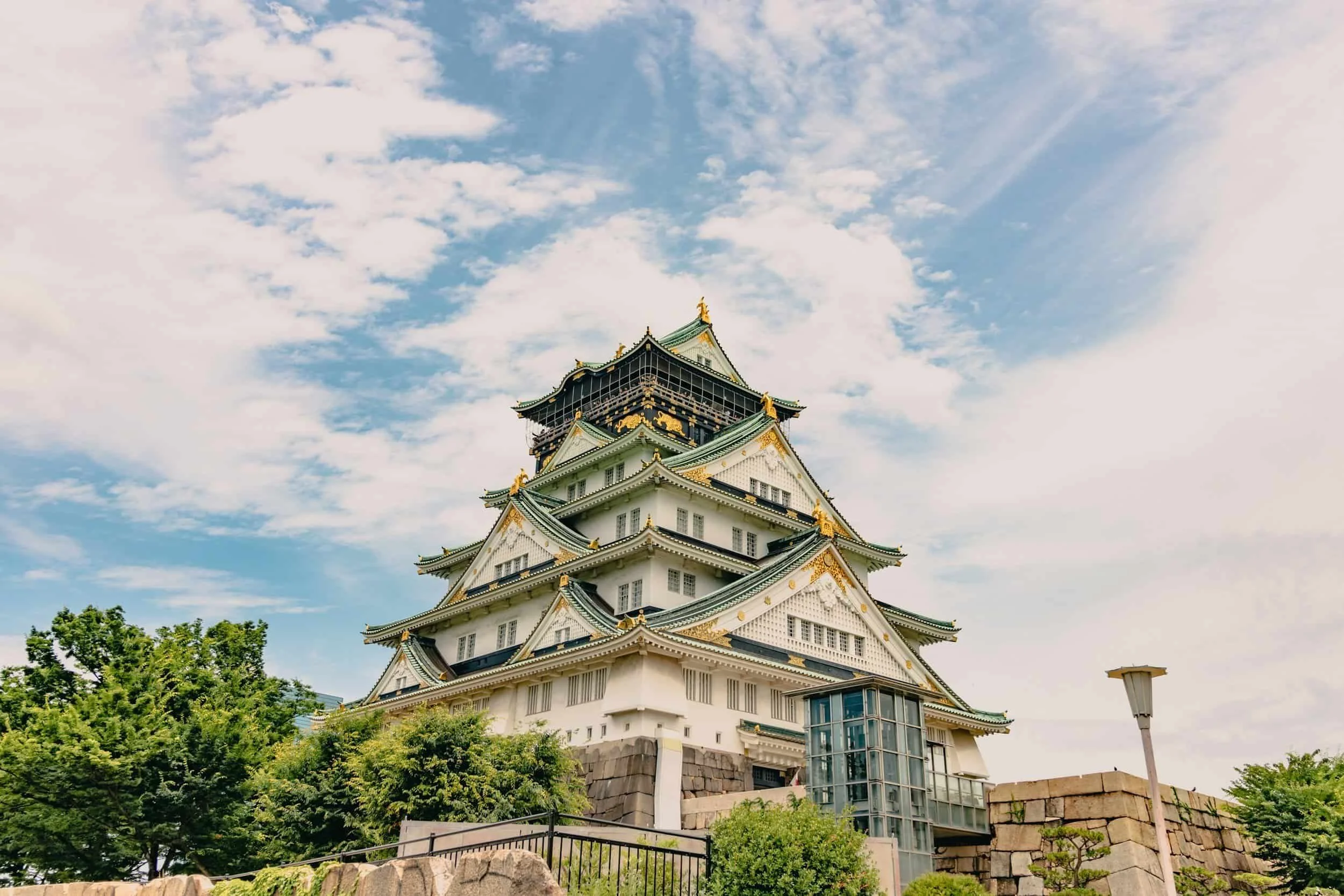 Château japonais entouré de verdure sous ciel nuageux, visite patrimoine au Japon.