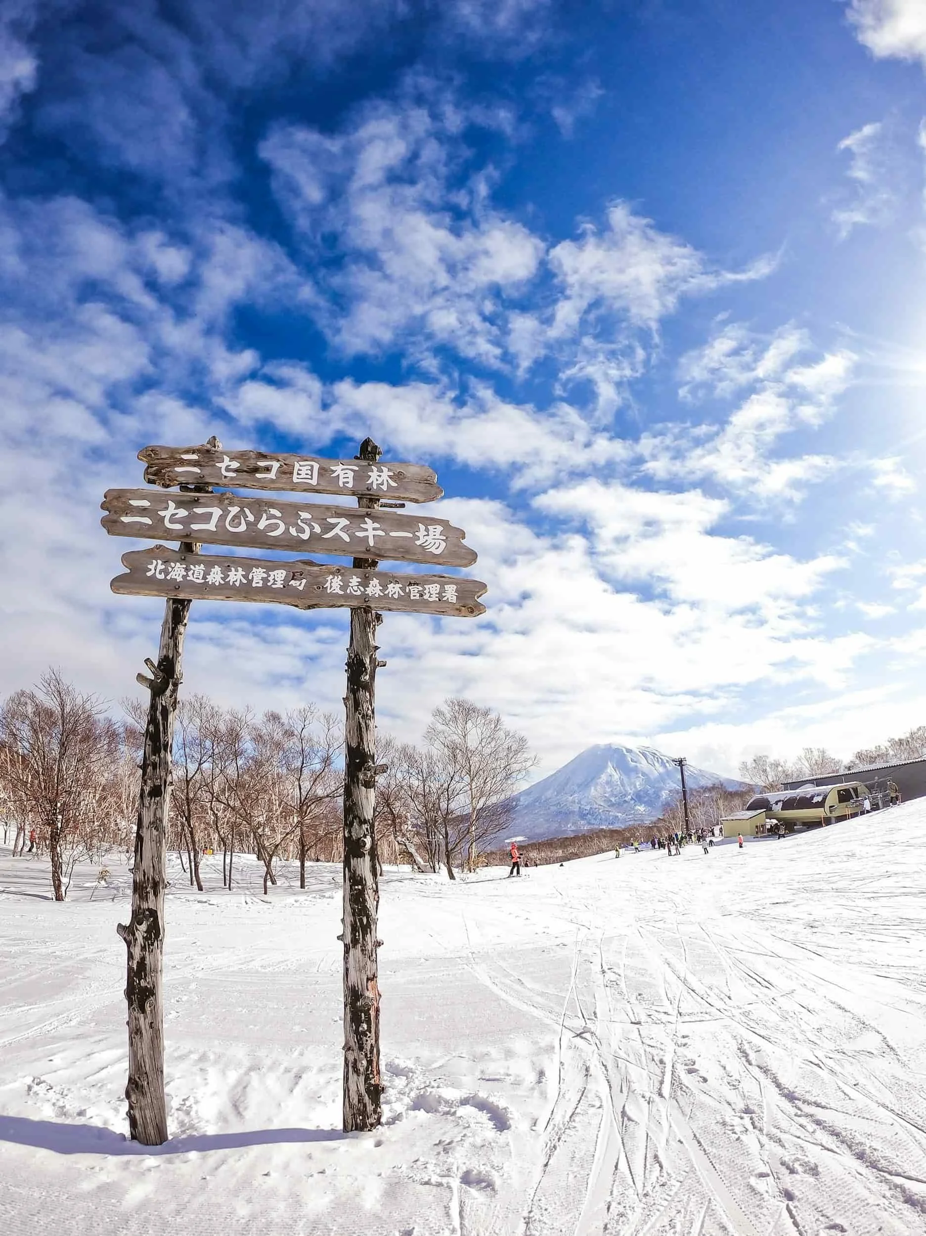 Paysage enneigé au Japon avec montagnes et panneau en japonais, hiver.