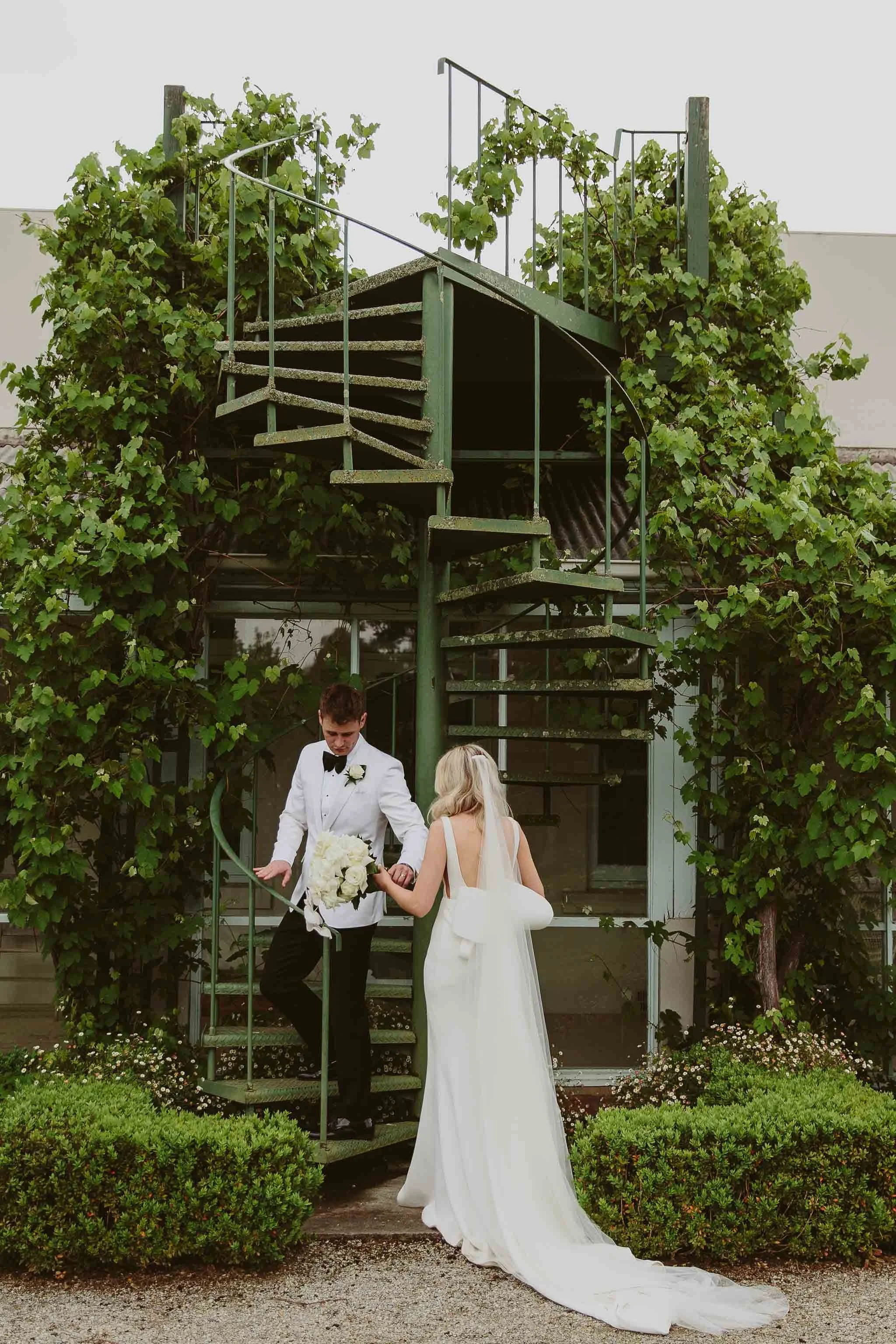 Bride and groom walking through the gardens at Coombe Yarra Valley