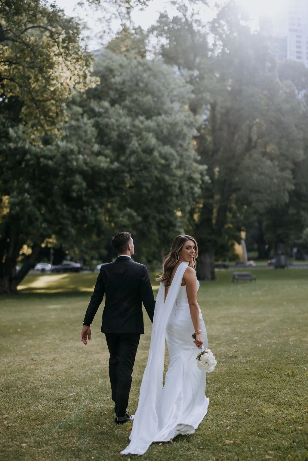 Husband and wife walking through Fitzroy Gardens