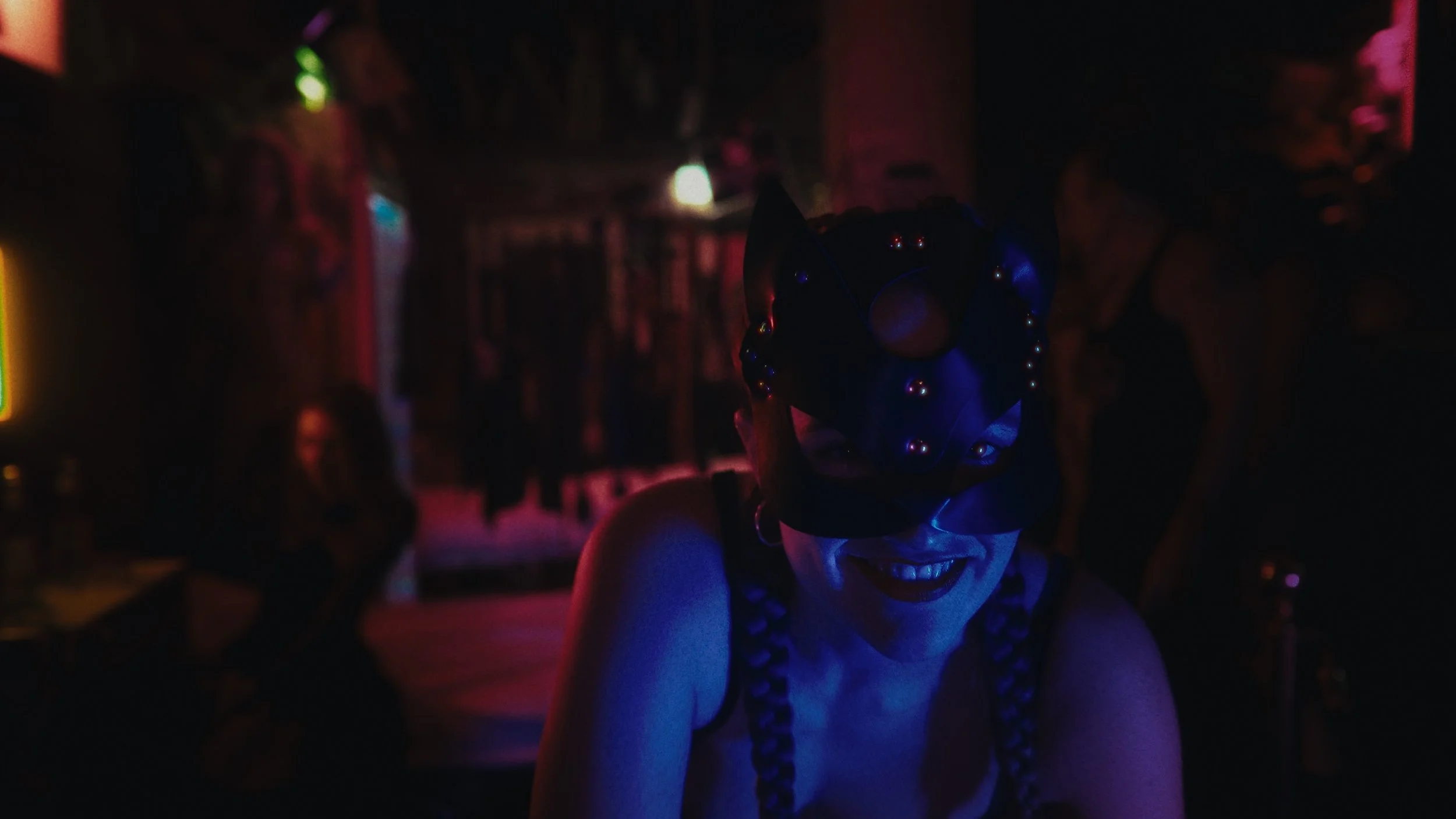 Donna con maschera da animale, sorriso, luci soffuse, ambiente notturno, feste o evento