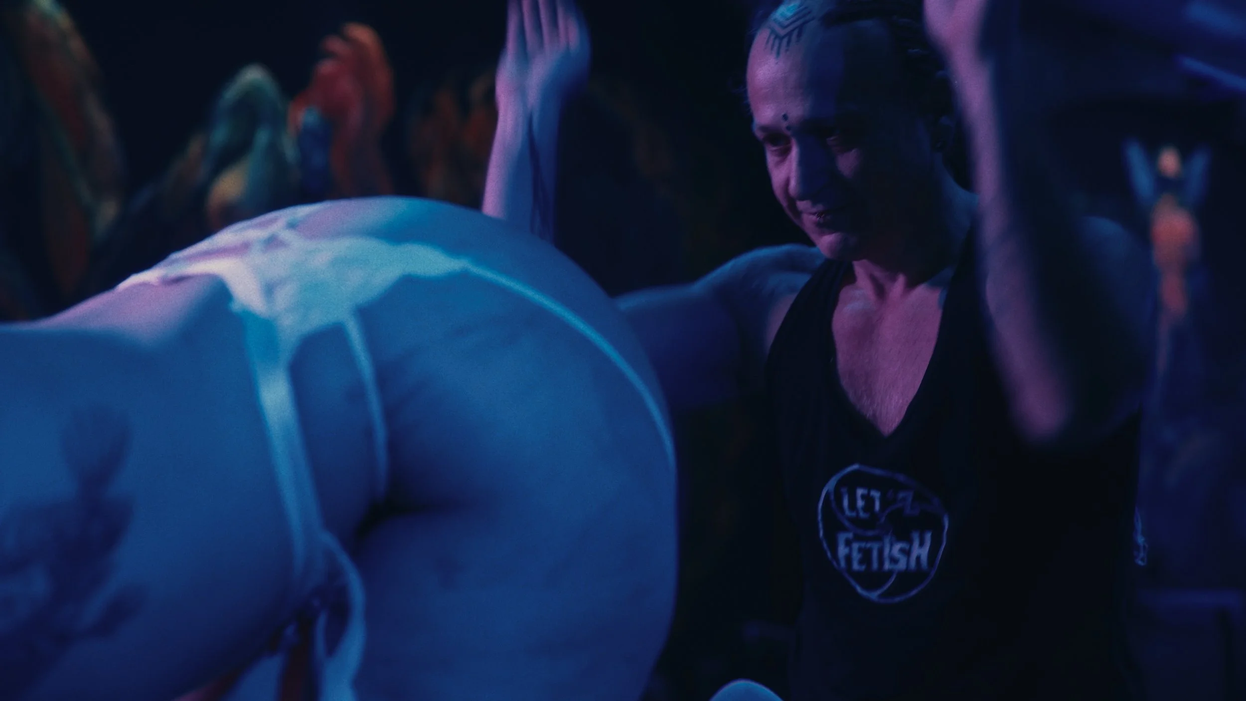 Persona in abbigliamento da palestra che si sta allenando in un ambiente con luci blu e viola