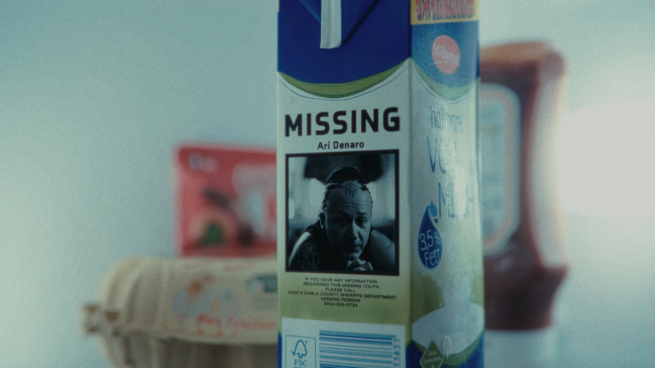 Cartone di latte con un avviso di persona scomparsa, mostra il testo 'MISSING', una foto di un uomo, e informazioni di contatto.