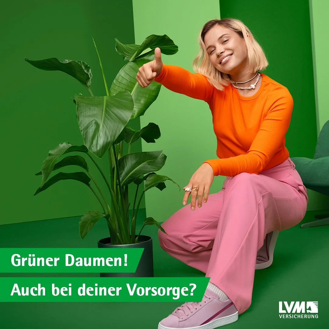 A young woman with blonde hair, wearing an orange shirt and pink pants, smiling and giving a thumbs-up while sitting next to a large green plant against a green background. Text overlay says 'Grüner Daumen! Auch bei deiner Vorsorge?' and a logo that 