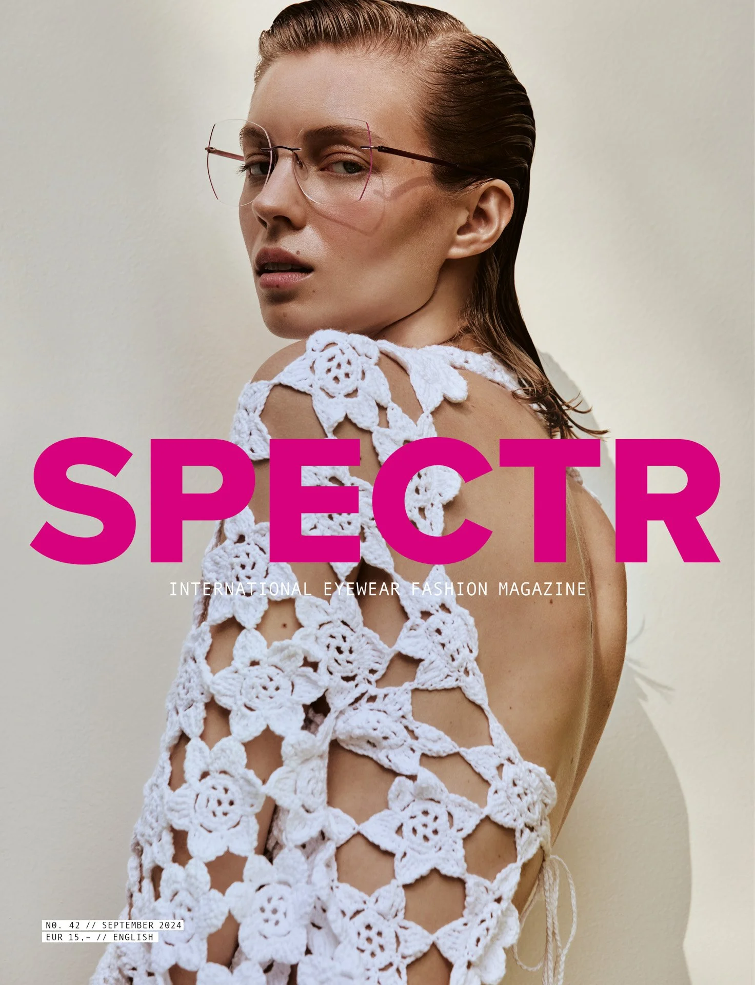 Cover of SPECTR international eyewear fashion magazine featuring a woman with slicked-back hair, wearing large eyeglasses and a white crocheted top with floral patterns.