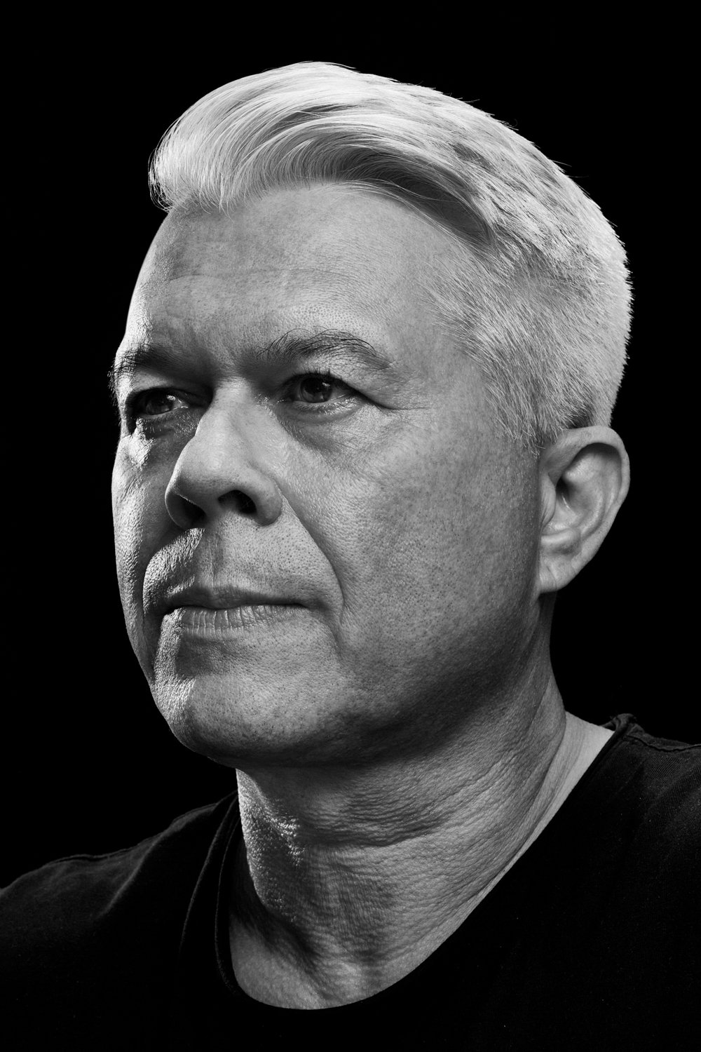 Black and white portrait of a middle-aged man with short, light-colored hair, looking slightly to the side.