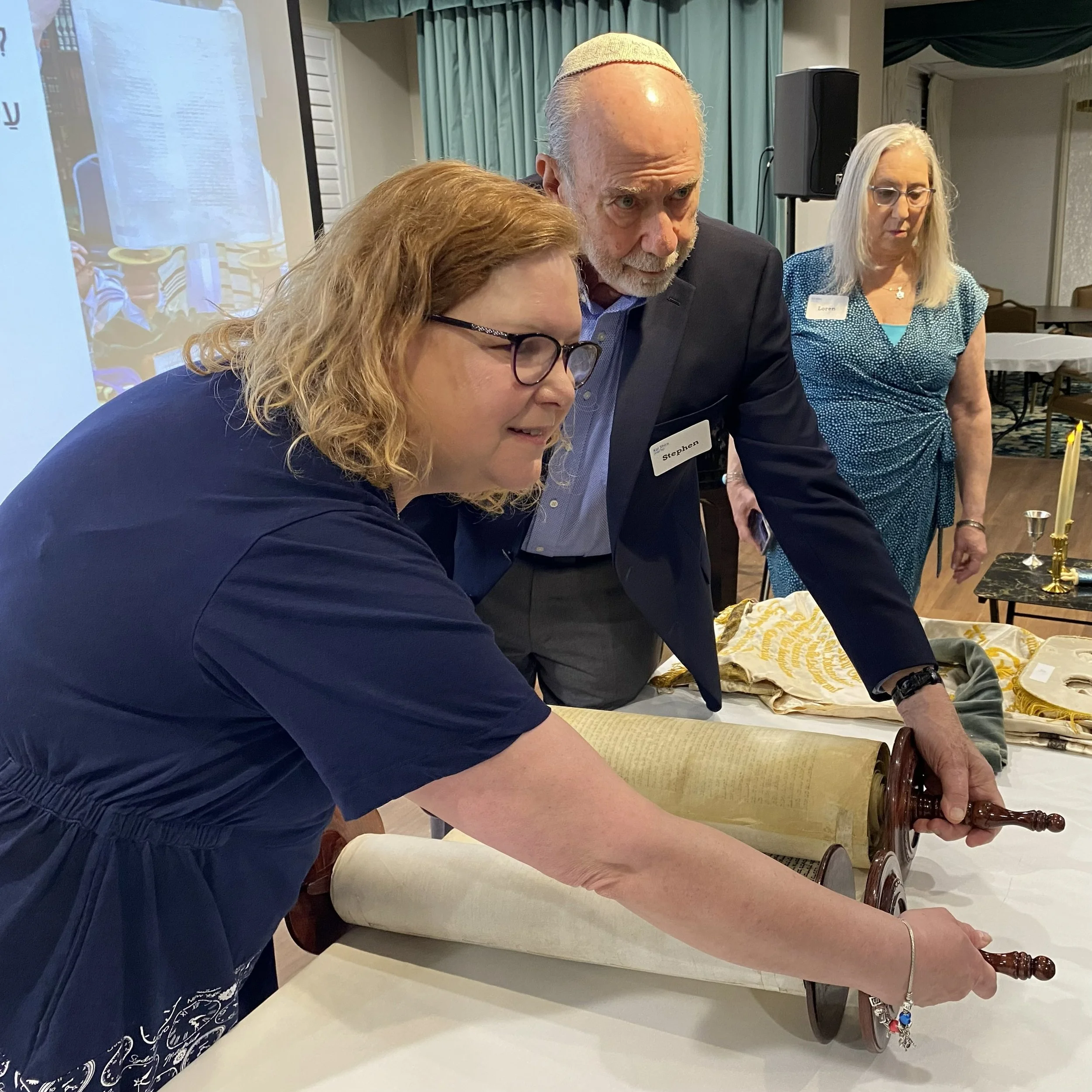 Two Kol Shira community members prepare to lift the Sefer Torah during the dedication service in Austin.