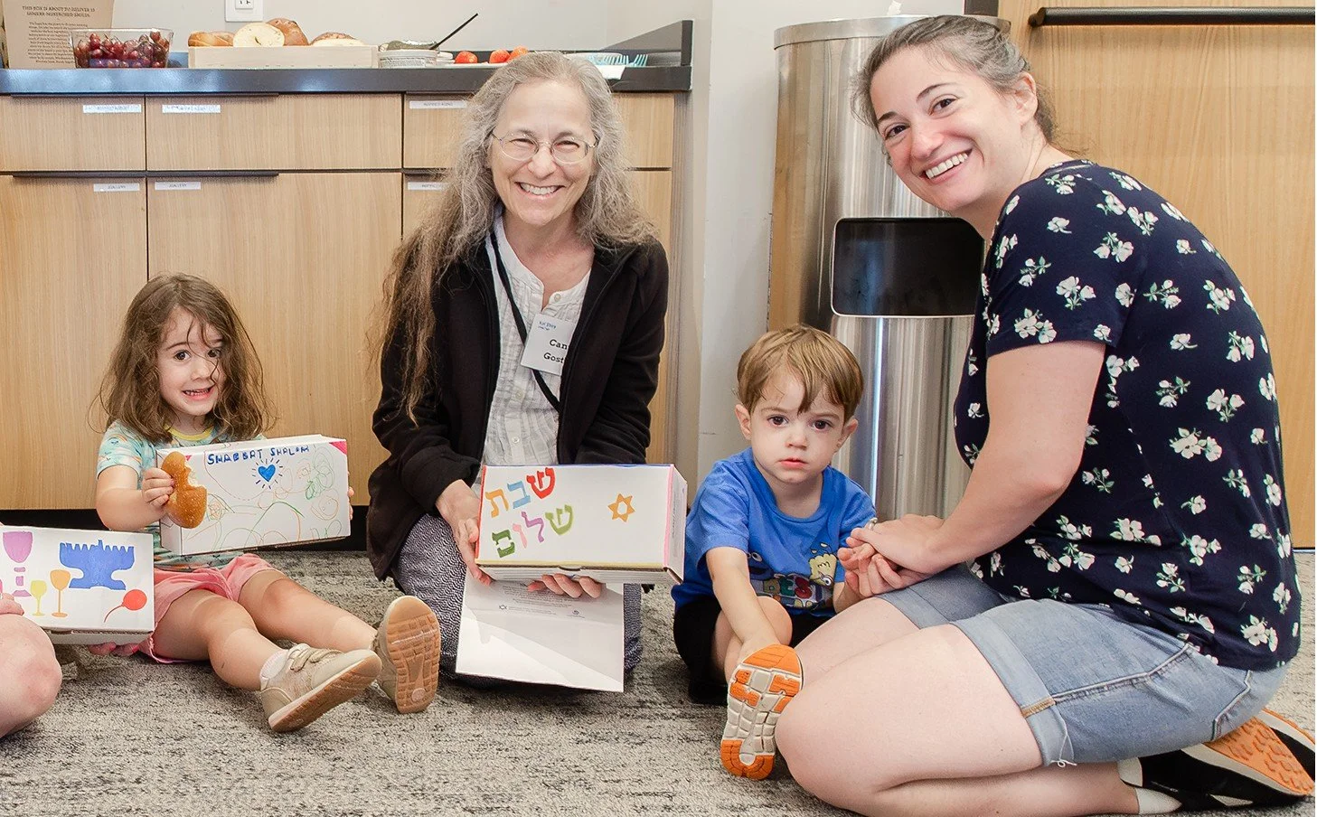 Kol Shira family with young children making Shabbat boxes for Jewish hospital patients.