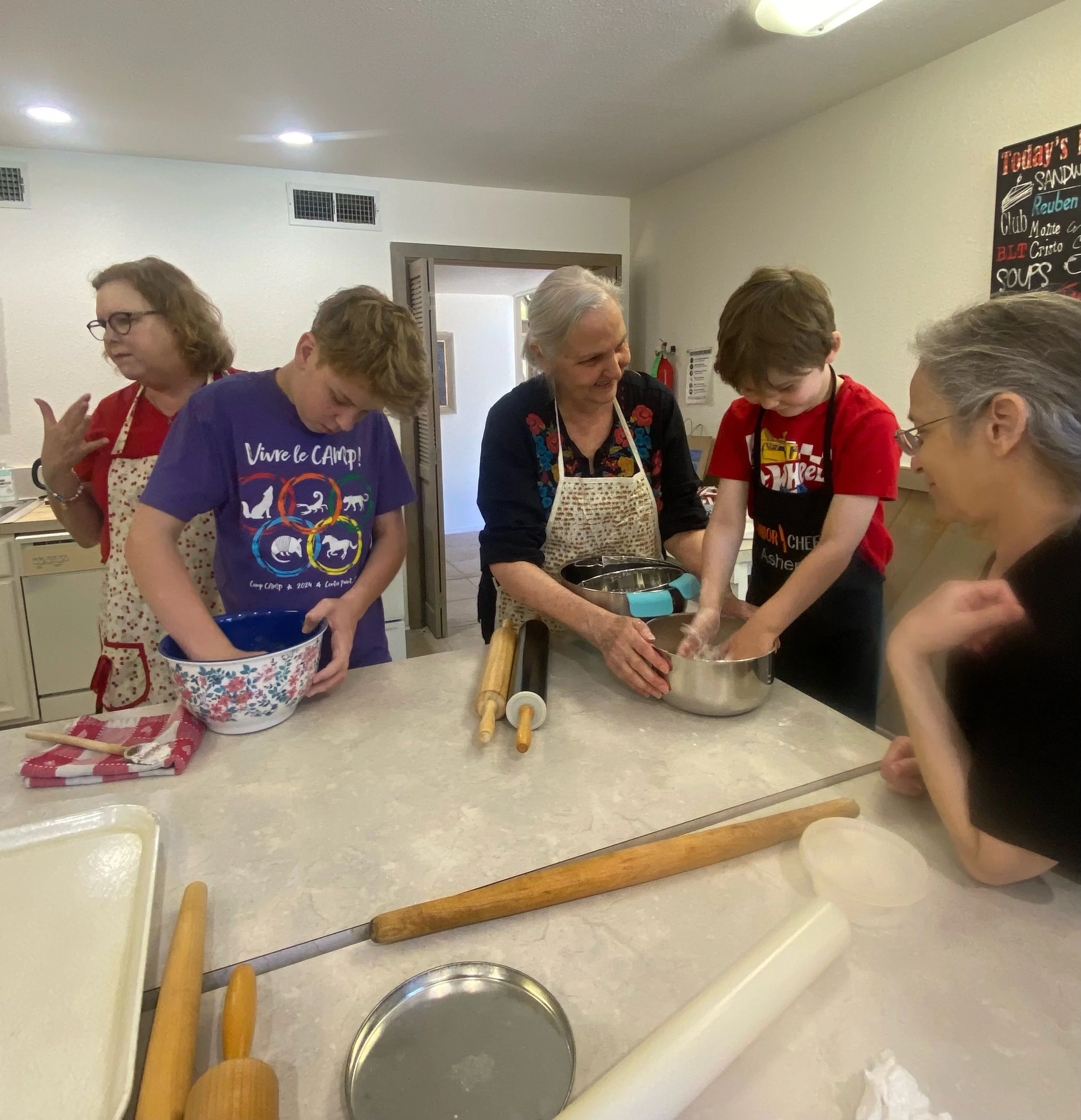 Kol Shira members of all ages participating a family education event to learn how to make home-made matzah for Passover.