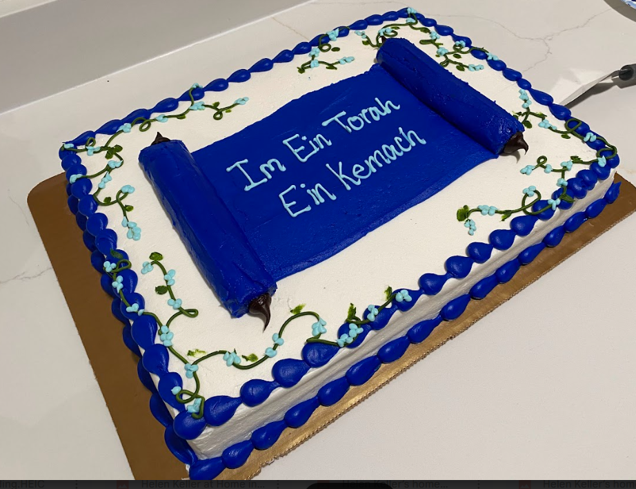 A closeup of a celebration cake at the Kol Shira Torah dedication service in Austin, featuring the Hebrew phrase Im Ein Torah, Ein Kemach, meaning Without Torah, there is no bread, or cake!