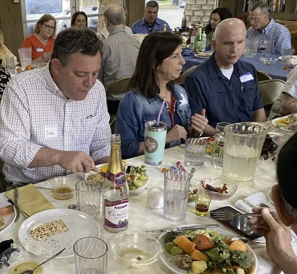Kol Shira community members enjoying a Seder meal with lively discussion at Passover 2026.