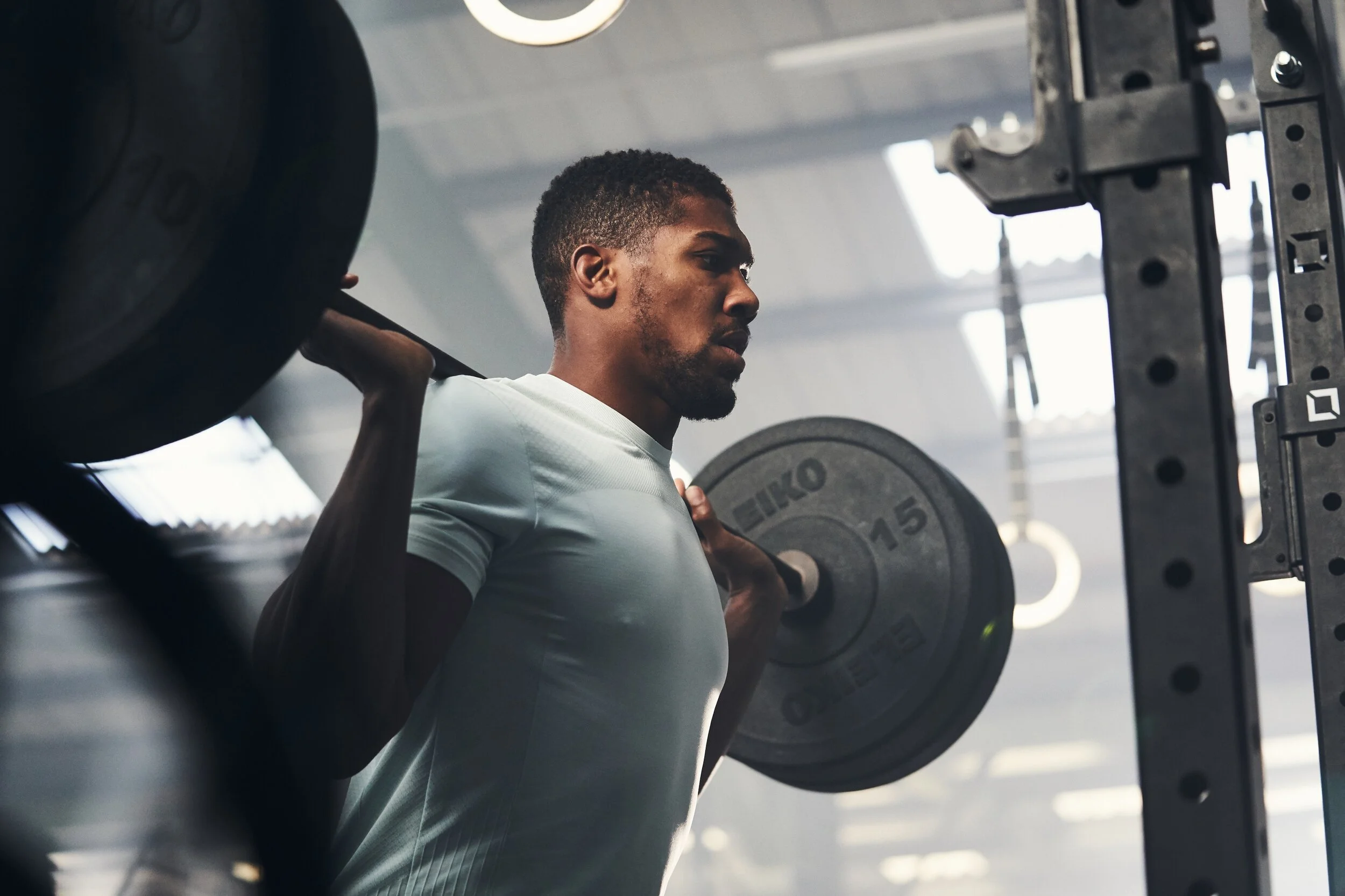 Man lifting a barbell with weights at gym.