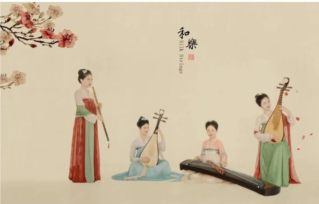 Quatre femmes en tenue traditionnelle chinoise jouant de différents instruments de musique, avec des fleurs de cerisier en décoration, le tout sur un fond beige clair.