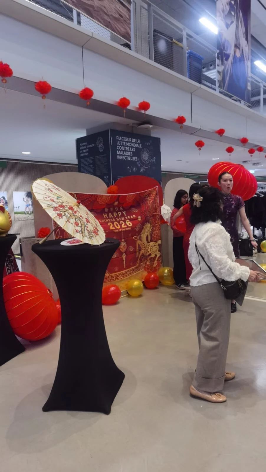 Décoration pour le Nouvel An chinois 2026 avec lanternes rouges, parasol et stand festif.