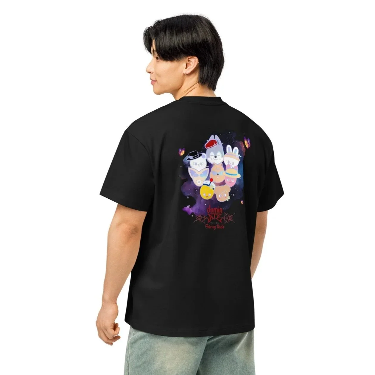 Une personne portant un t-shirt noir avec un graphisme coloré de personnages mignons et des éléments saisonniers, avec le texte 'dannn SEASON BIDE' en dessous.
