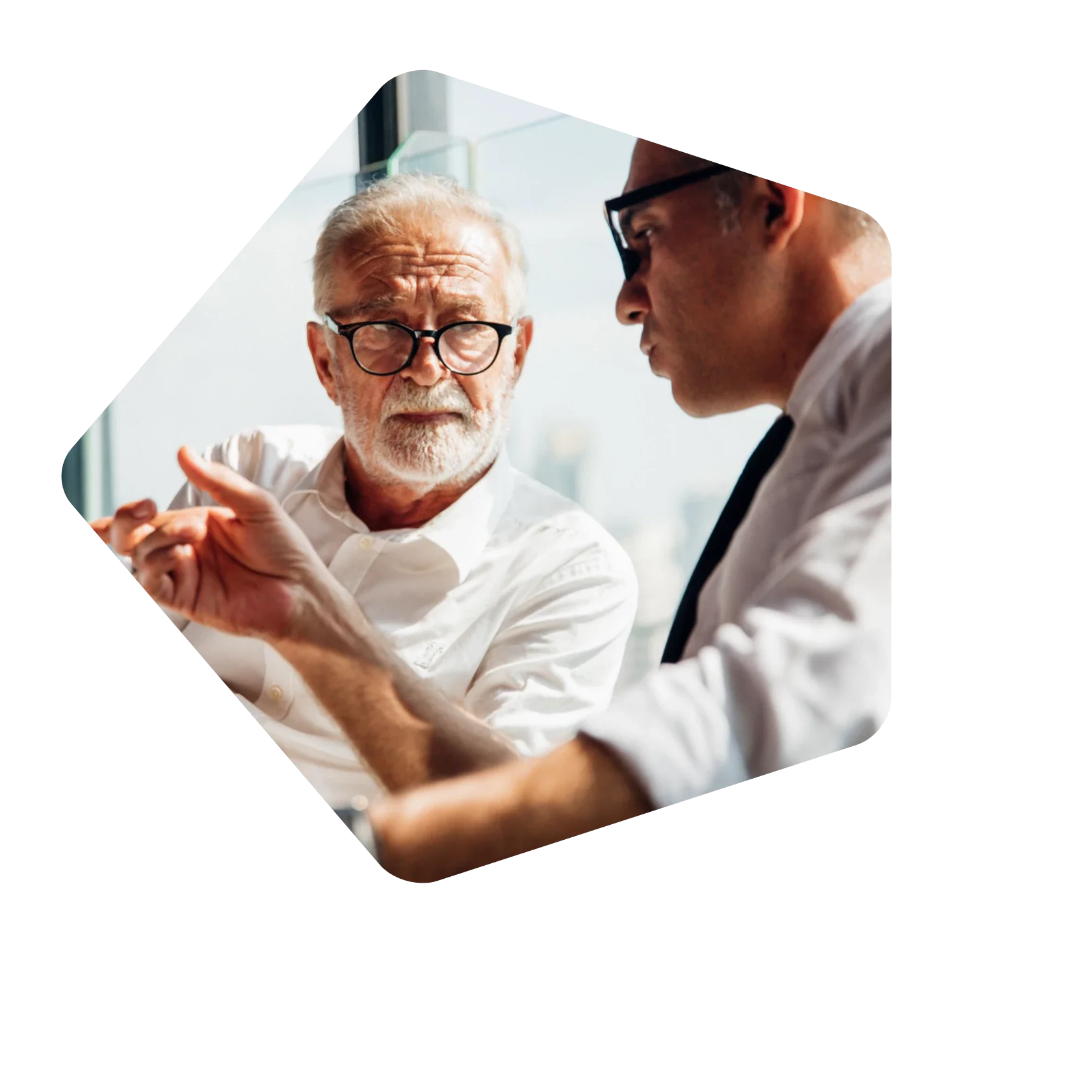 Older_man_in_white_shirt_talking_to_work_colleague.webp