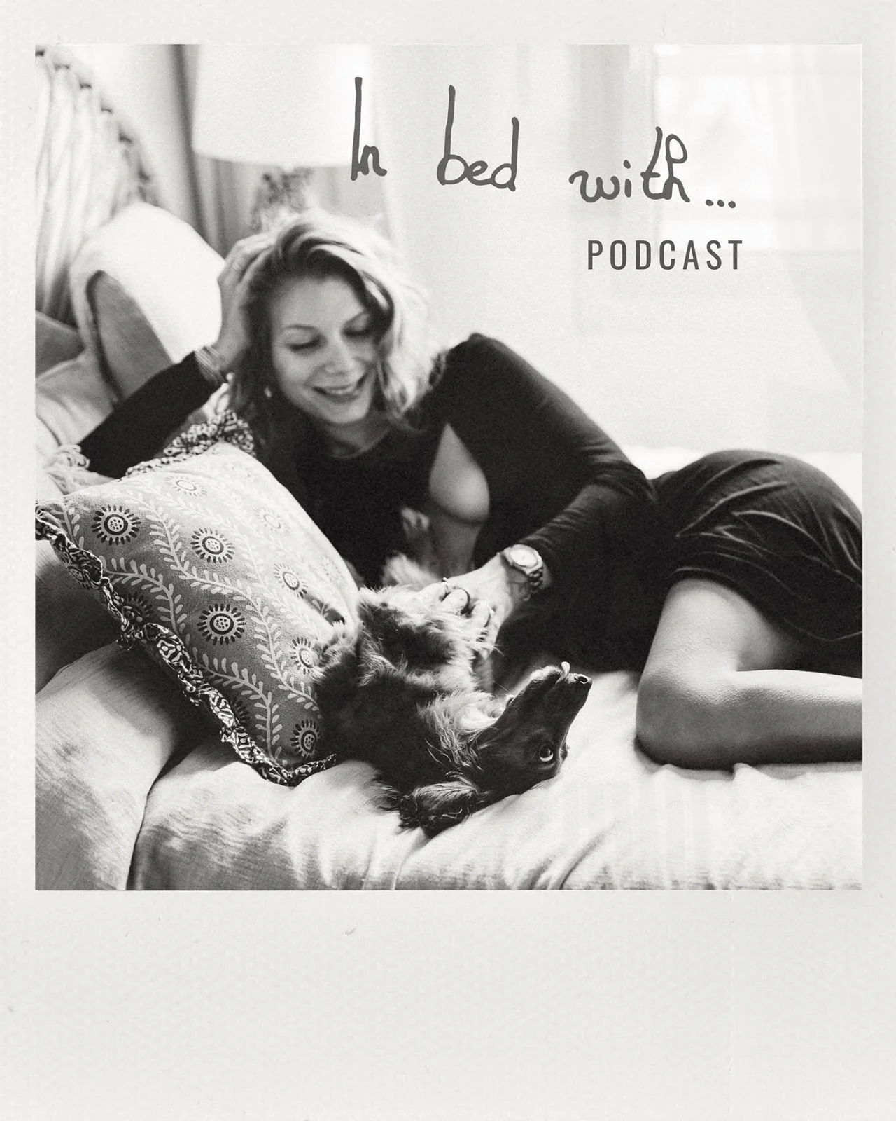 Une femme blonde souriante allongée sur un lit, caressant un chien allongé sur le dos. Le texte à l'écran indique « In bed with... PODCAST ».