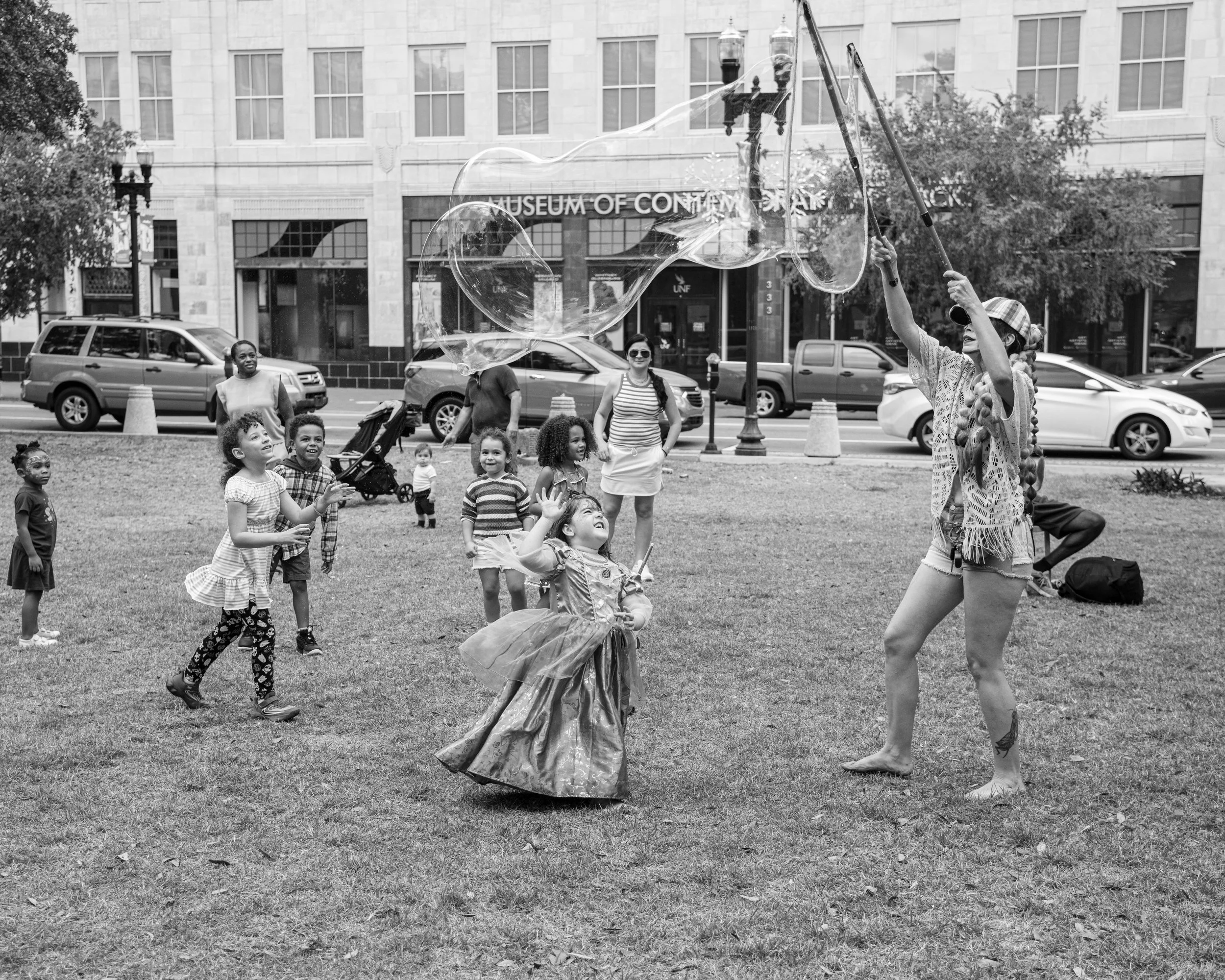 Children playing in park with Bubble Artist.