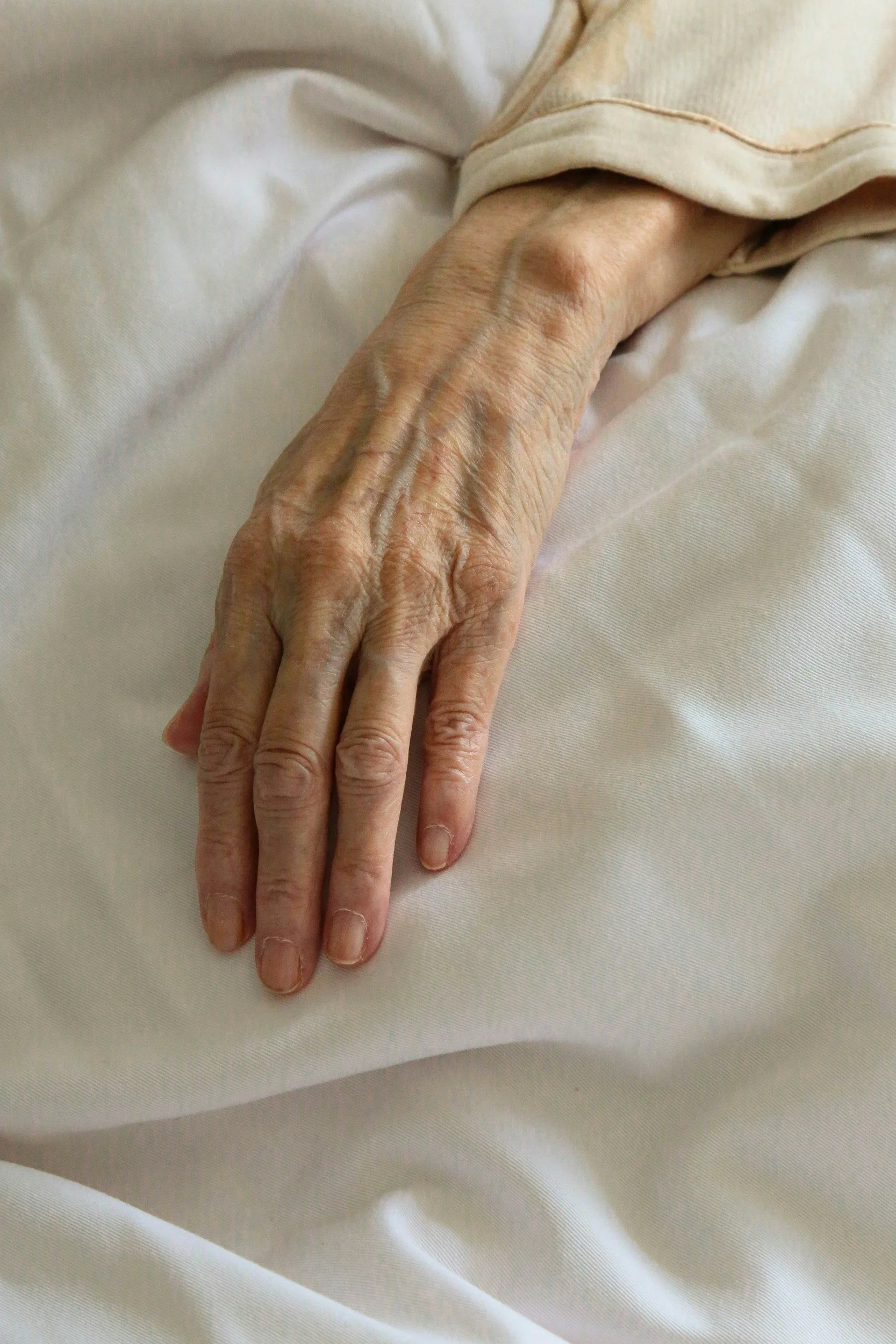 a hand against a white bedsheet