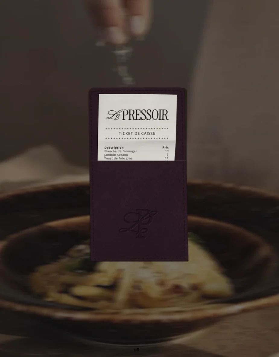 Ticket de caisse déposé dans une pochette violette, au-dessus d'une assiette de pâtes.