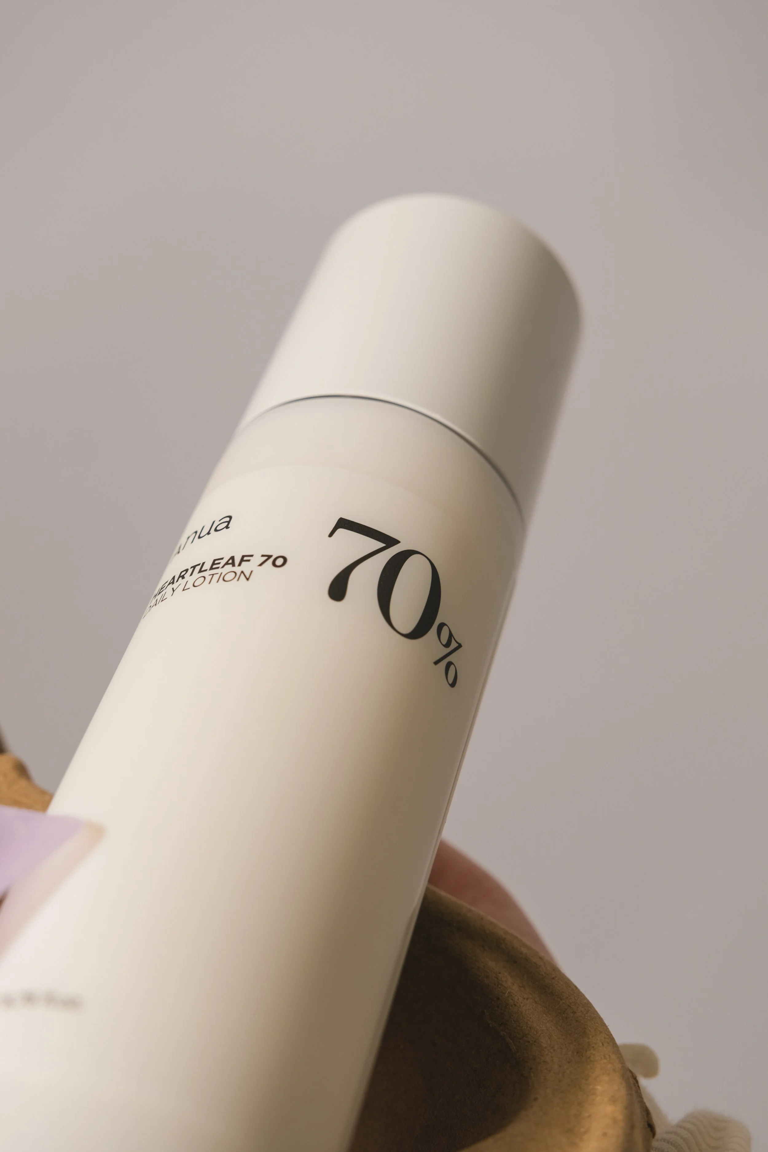 Flacon blanc avec une étiquette partiellement visible, indiquant un pourcentage de 70%.