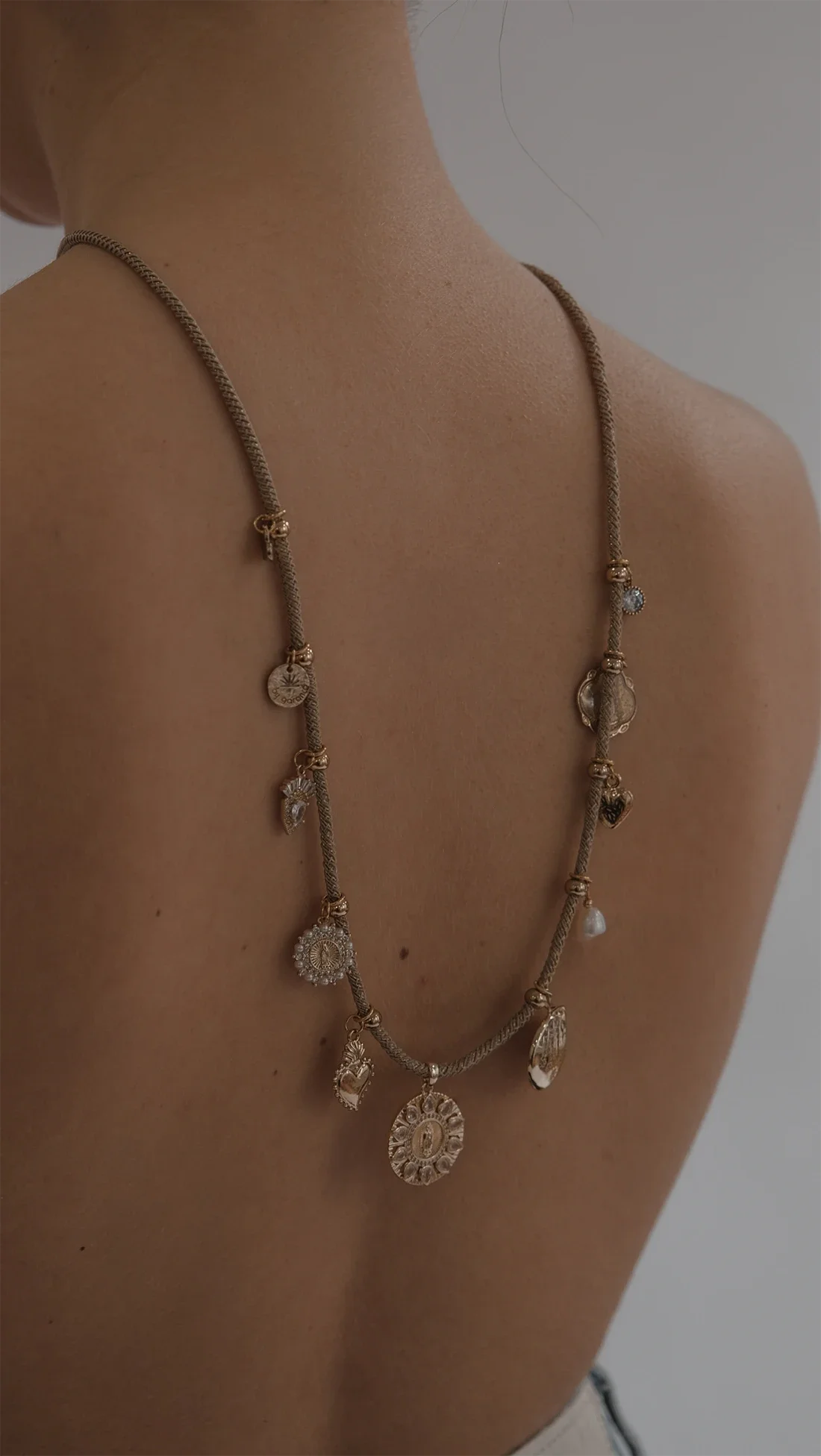 Collier en or avec divers pendentifs suspendus.