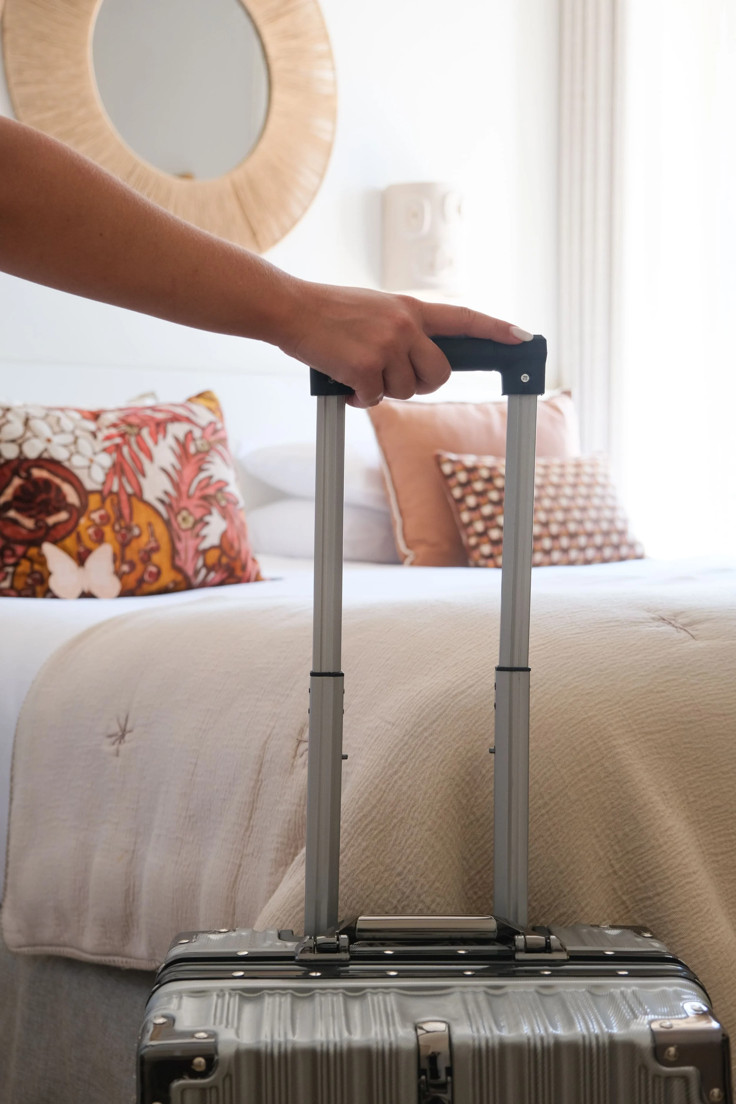 Une valise devant un lit dans une chambre d'hôtel.