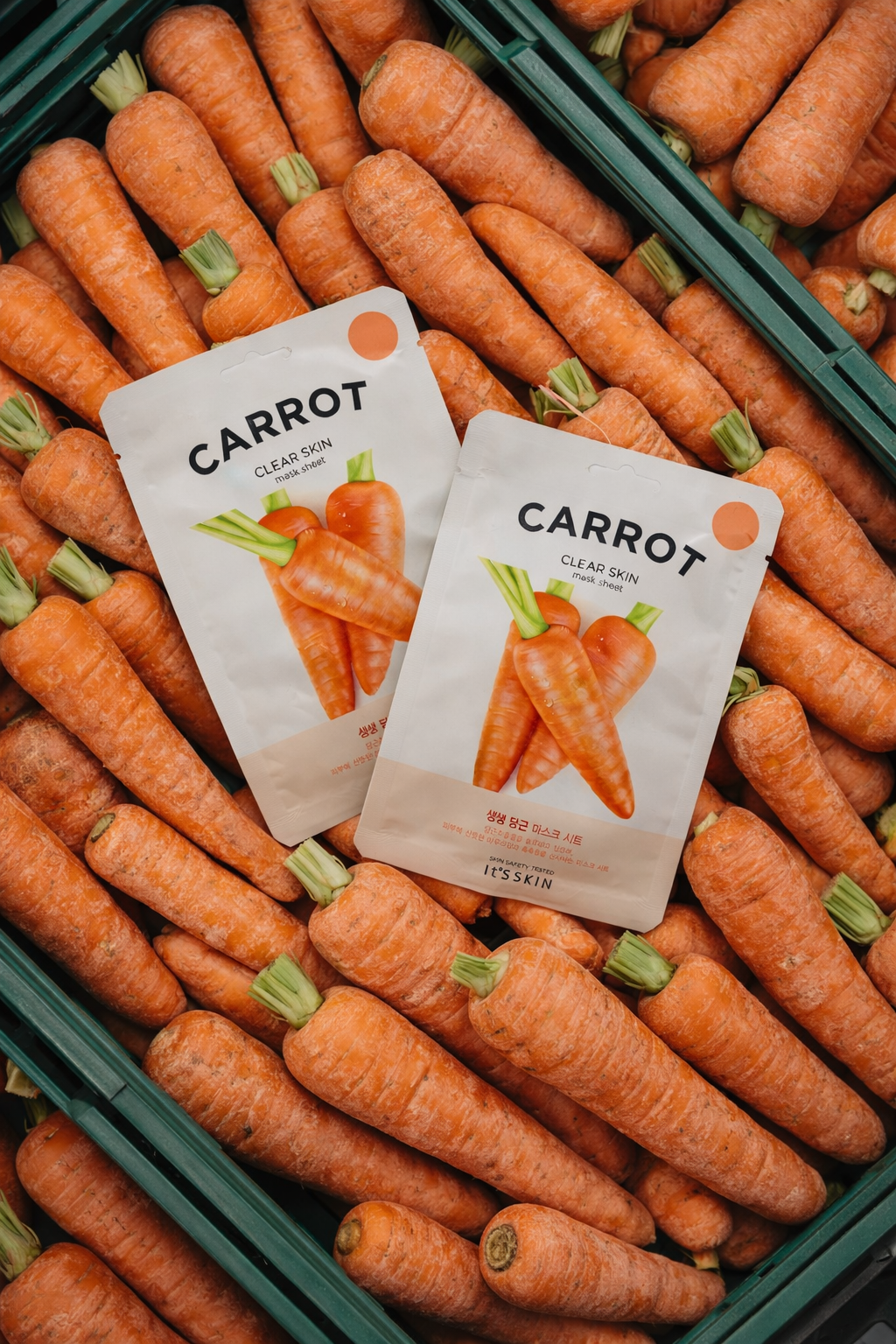 Carottes fraîches dans une caisse avec deux sachets de masque facial à base de carotte
