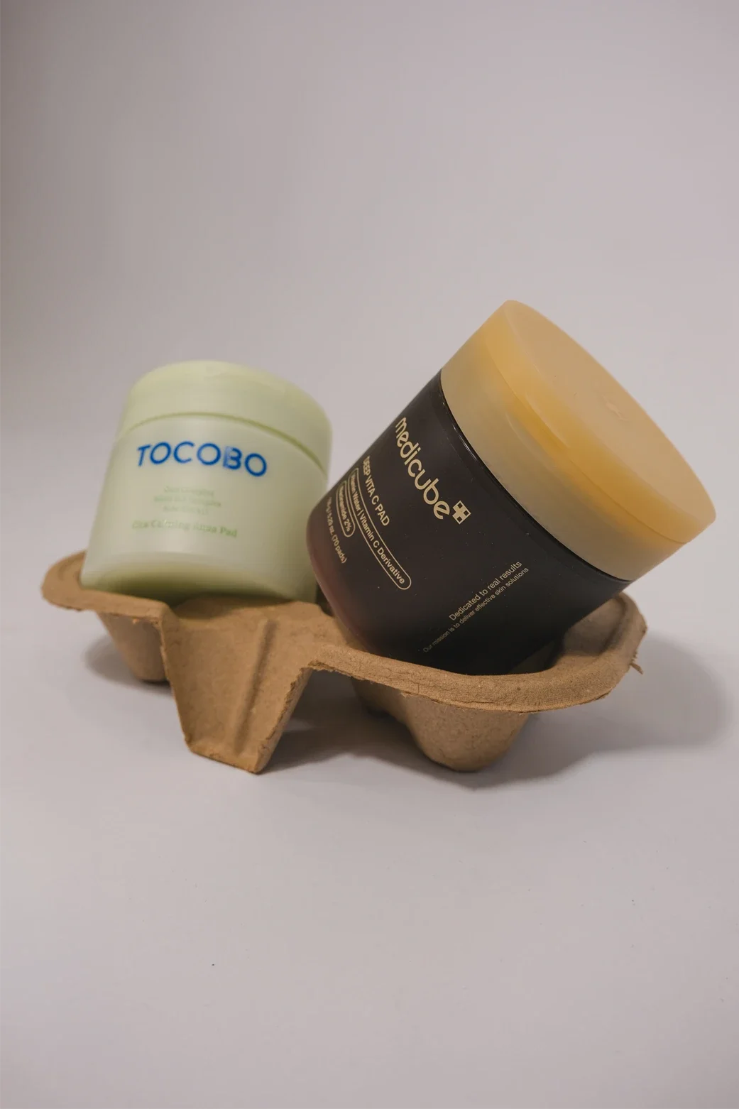 Deux pots de crème sur un support en carton recyclé