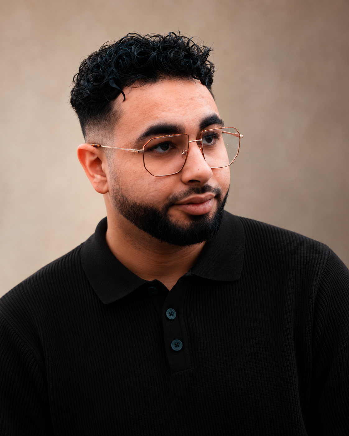 Devid Kelada, founder of Nex Era Studios, wearing glasses and a black polo shirt.